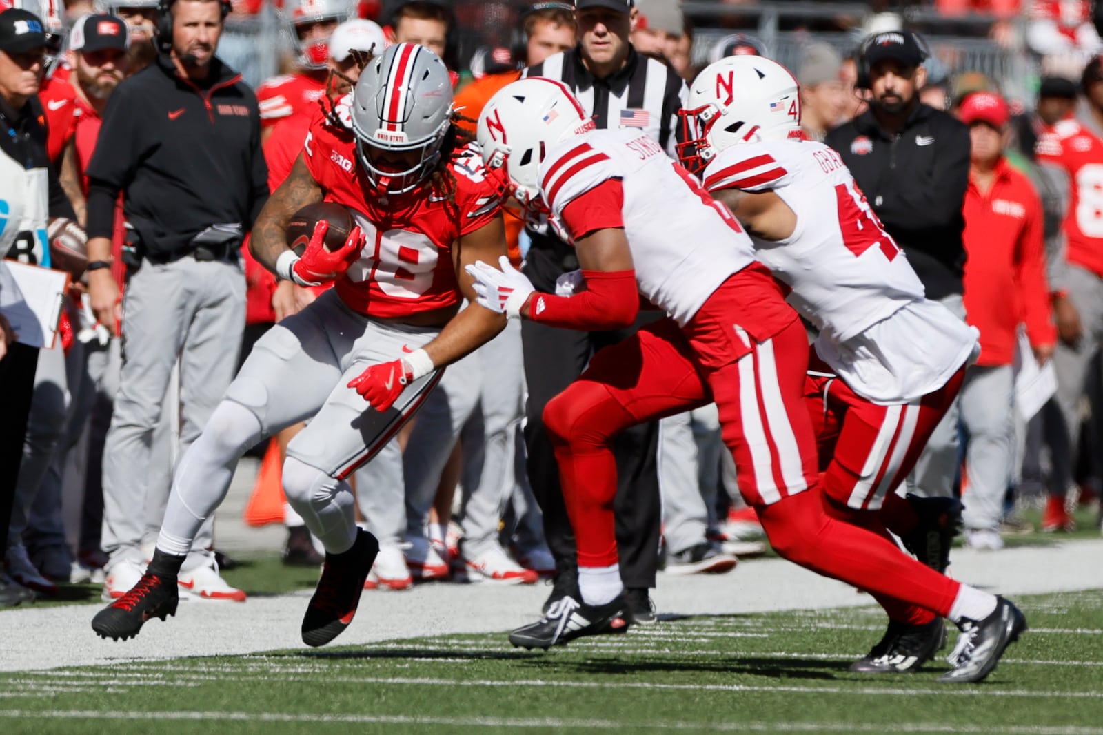 Nebraska defensive back DeShon Singleton, center, and linebacker Mikai Gbayor, right, force Ohio State tight end Gee Scott out of bounds during the first half of an NCAA college football game Saturday, Oct. 26, 2024, in Columbus, Ohio. (AP Photo/Jay LaPrete)