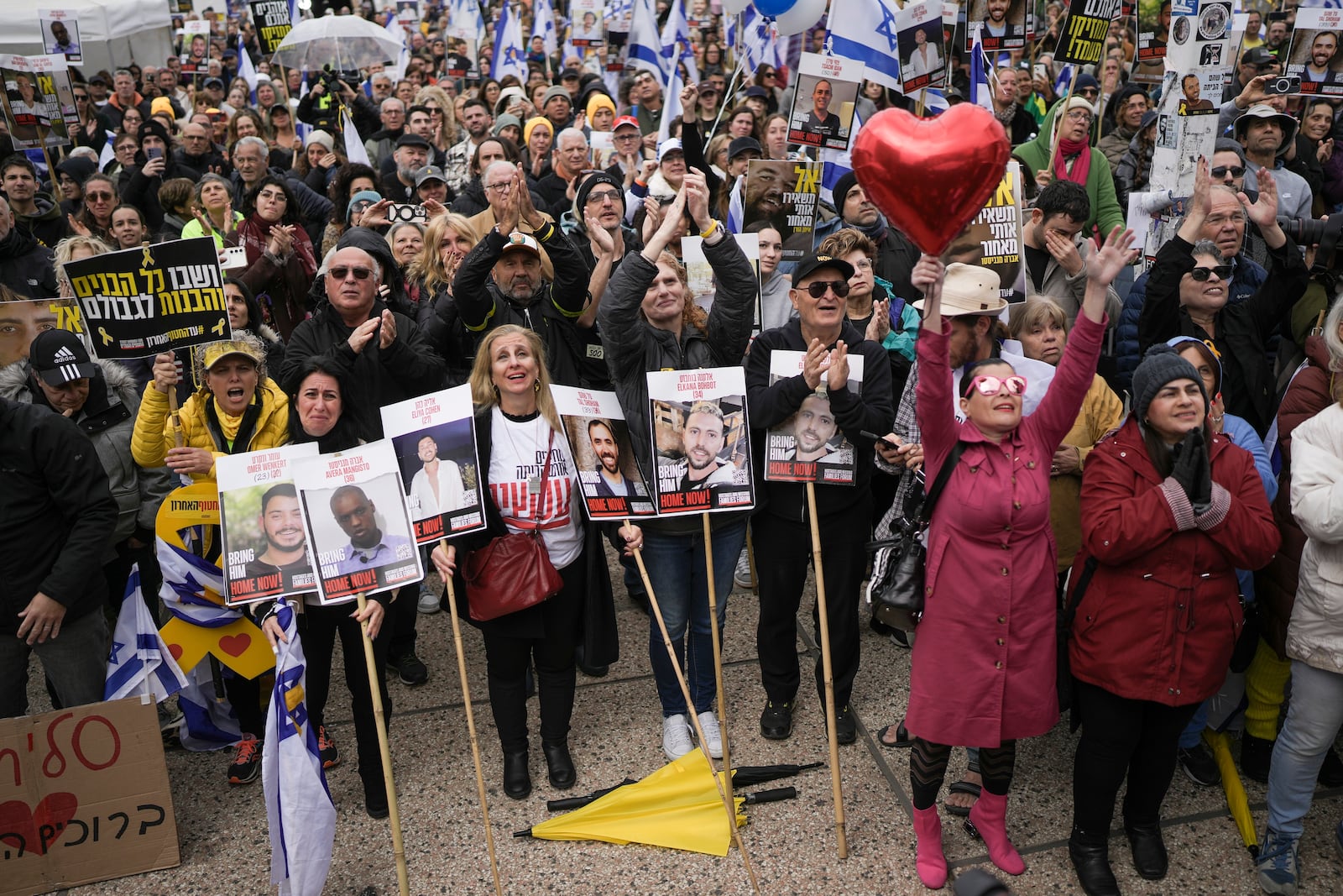 Israelis react as the first two of six hostages to be released in Gaza by Palestinian militants are handed over to the Red Cross as they watch a live broadcast in 'Hostages Square' in Tel Aviv, Israel, Saturday Feb. 22, 2025. (AP Photo/Oded Balilty)