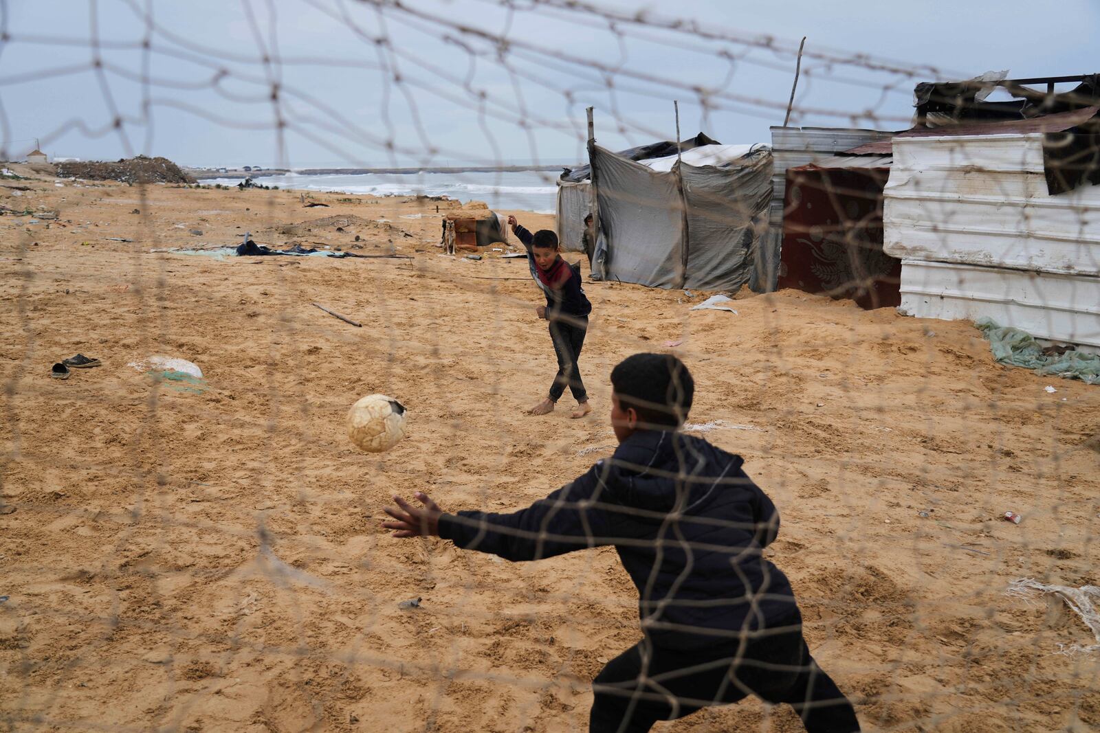 Displaced Palestinians kids play soccer at a makeshift tent camp in Deir al-Balah, Gaza Strip on Saturday, March 22, 2025. (AP Photo/Abdel Kareem Hana)