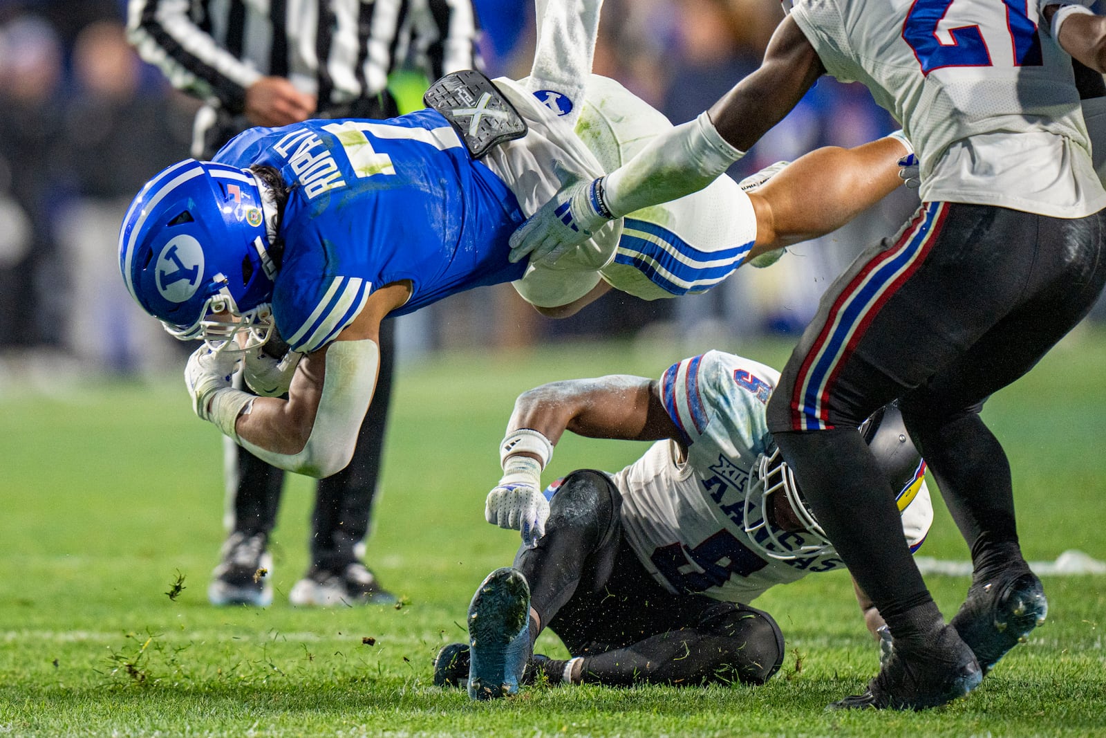 Brigham Young Cougars running back Hinckley Ropati (7) is tripped up by Kansas Jayhawks safety O.J. Burroughs (5) during the first half of an NCAA college football game Saturday, Nov. 16, 2024, in Provo. (AP Photo/Rick Egan)