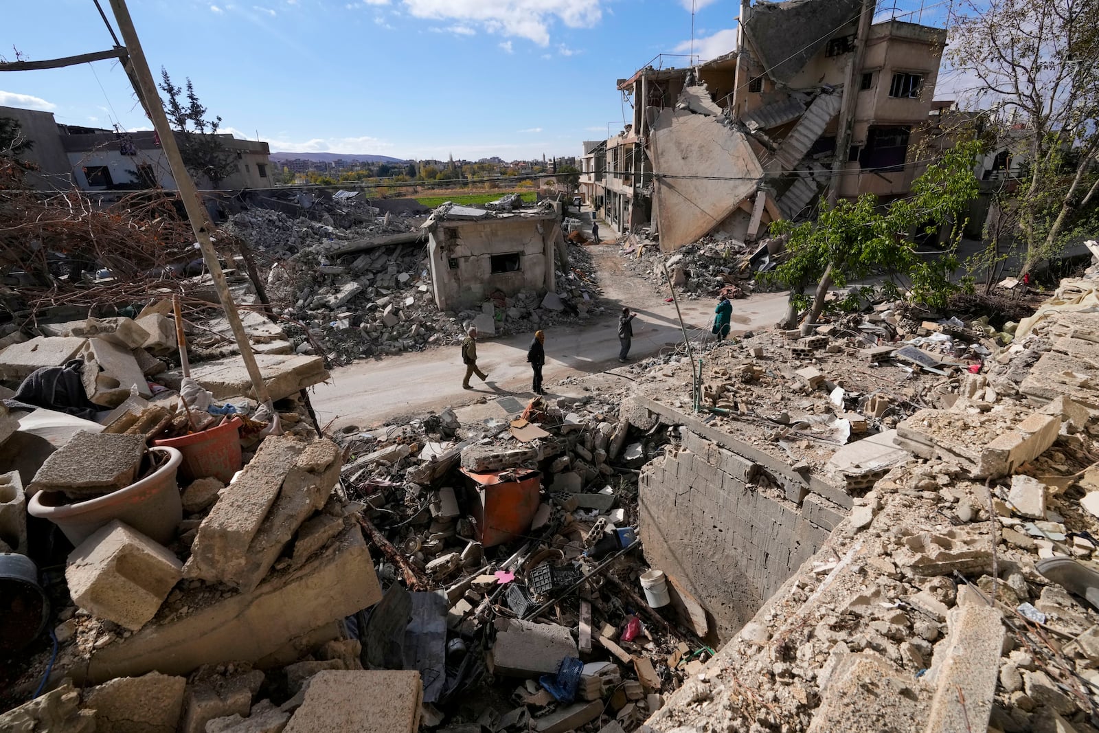 Residents check their destroyed neighborhood in Baalbek, eastern Lebanon, Thursday, Nov. 28, 2024. (AP Photo/Hassan Ammar)