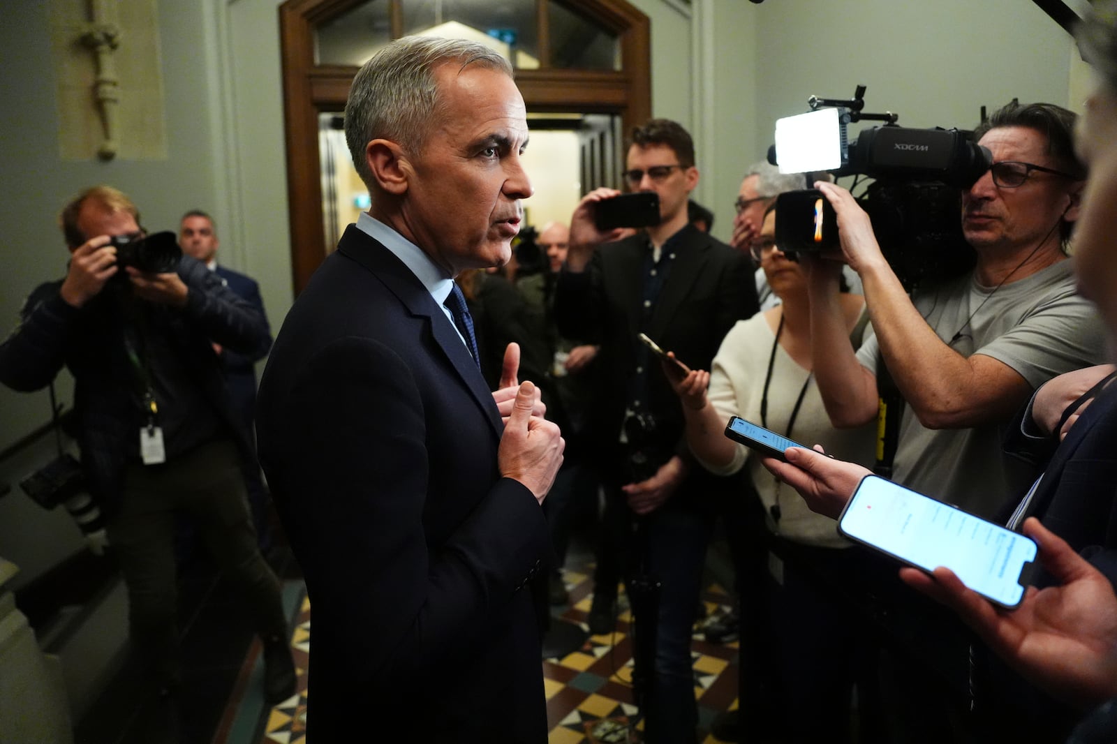 Canada Liberal Leader Mark Carney talks to media as he leaves a caucus meeting in Ottawa, Monday, March 10, 2025. (Sean Kilpatrick/The Canadian Press via AP)