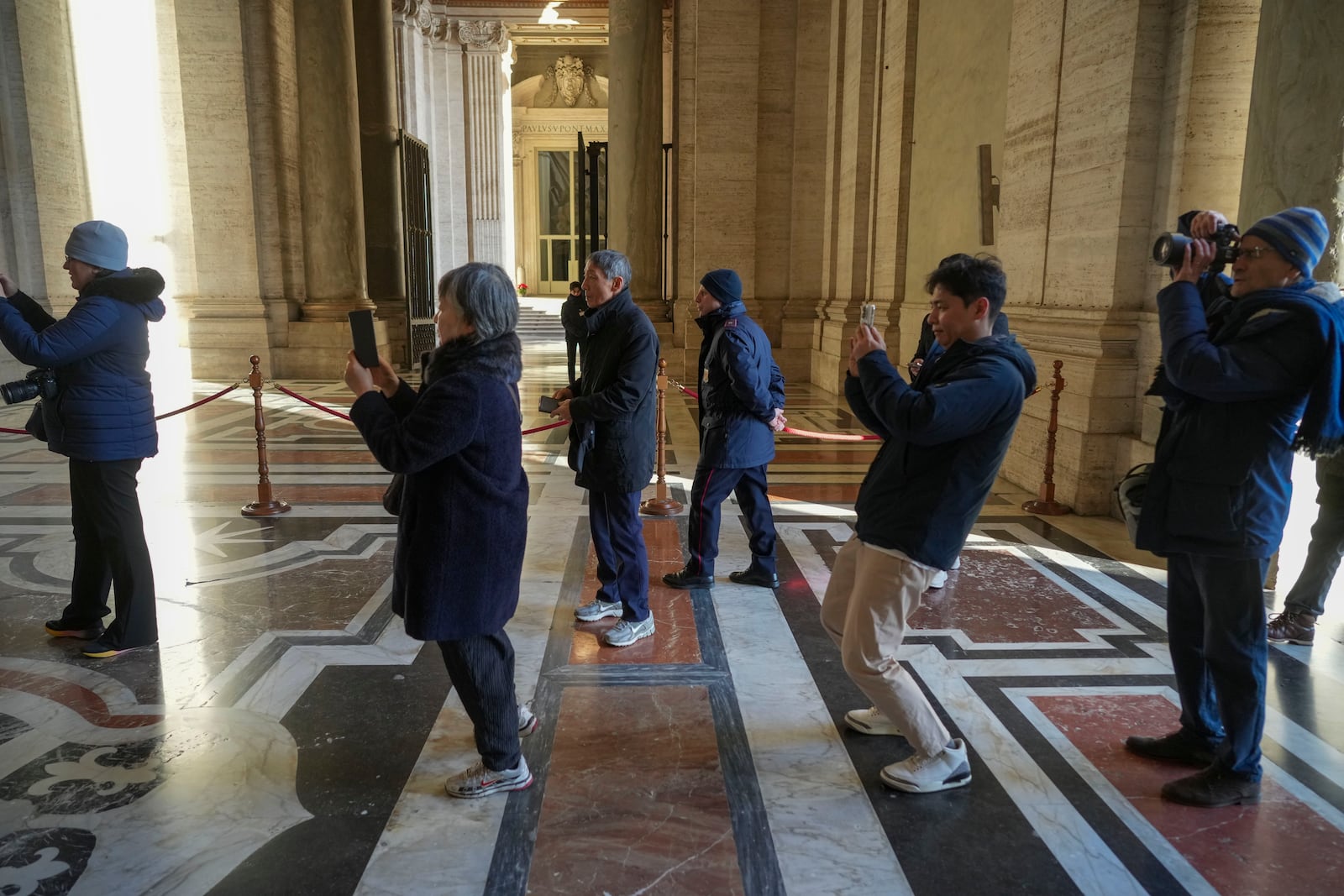 Faithful take photos as they arrive to walk through the Holy Door of St. Peter's Basilica at the Vatican, Wednesday, Dec. 25, 2024, after it was opened by Pope Francis on Christmas Eve marking the start of the Catholic 2025 Jubilee. (AP Photo/Andrew Medichini)