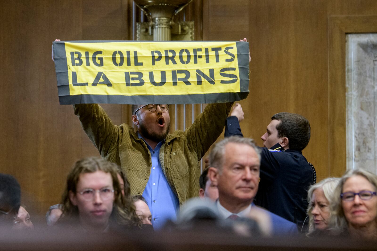 A protestor interrupts Chris Wright, President-elect Donald Trump's nominee to be Secretary of Energy, as he testifies during a Senate Committee on Energy and Natural Resources hearing for his pending confirmation, on Capitol Hill, Wednesday, Jan. 15, 2025, in Washington. (AP Photo/Rod Lamkey, Jr.)