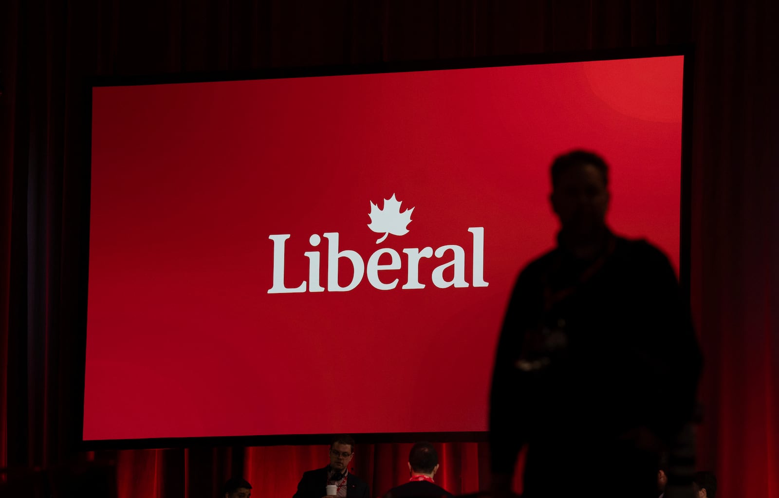 A photographer walks through the room ahead of the Liberal leadership announcement, Sunday, March 9, 2025 in Ottawa. (Adrian Wyld/The Canadian Press via AP)