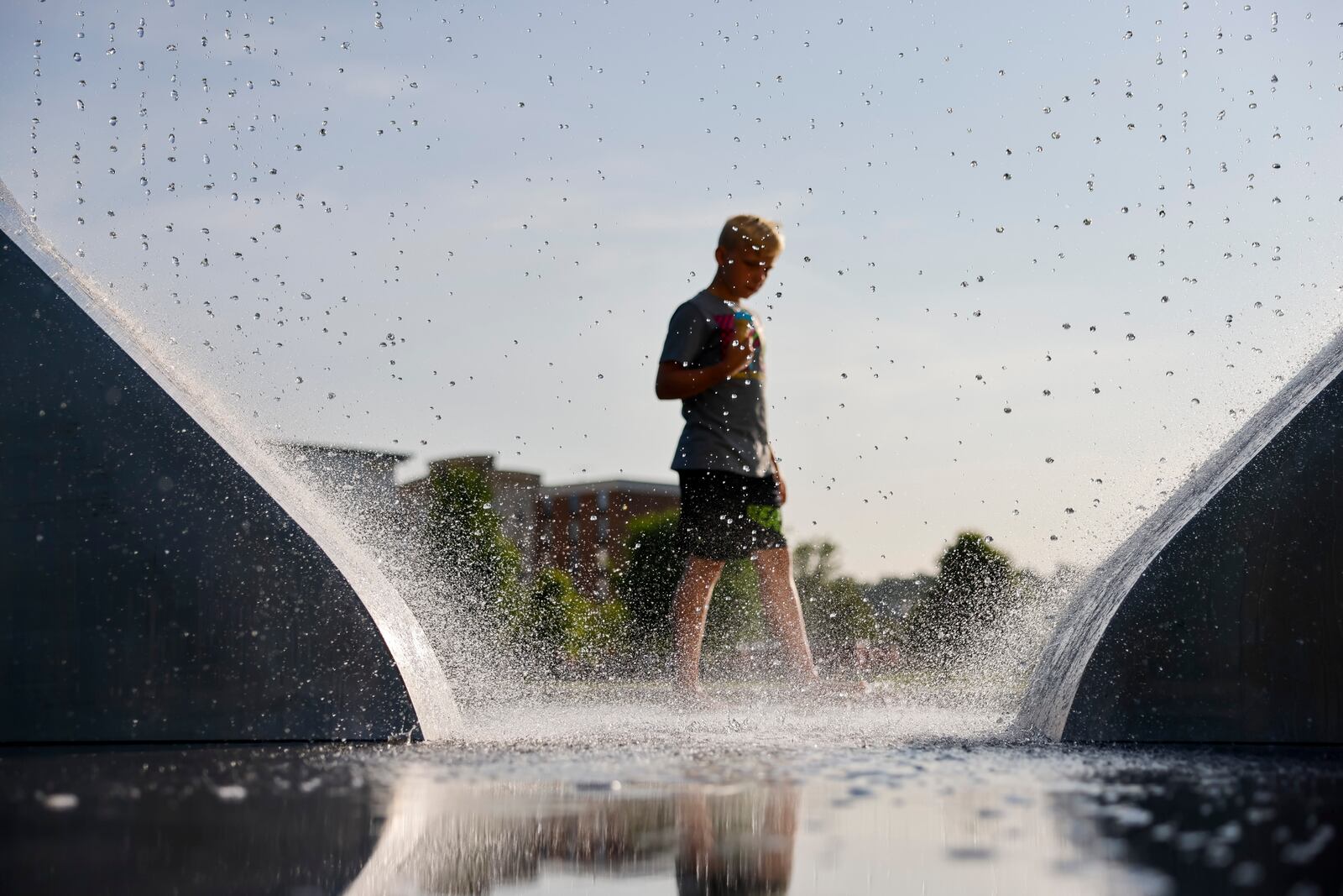 People gather at Marcum Park for the first concert of the season Thursday, May 25, 2023 at RiversEdge Amphitheater in Hamilton. Pictured in this file photo is a boy playing in the water feature at Marcum Park. NICK GRAHAM/FILE