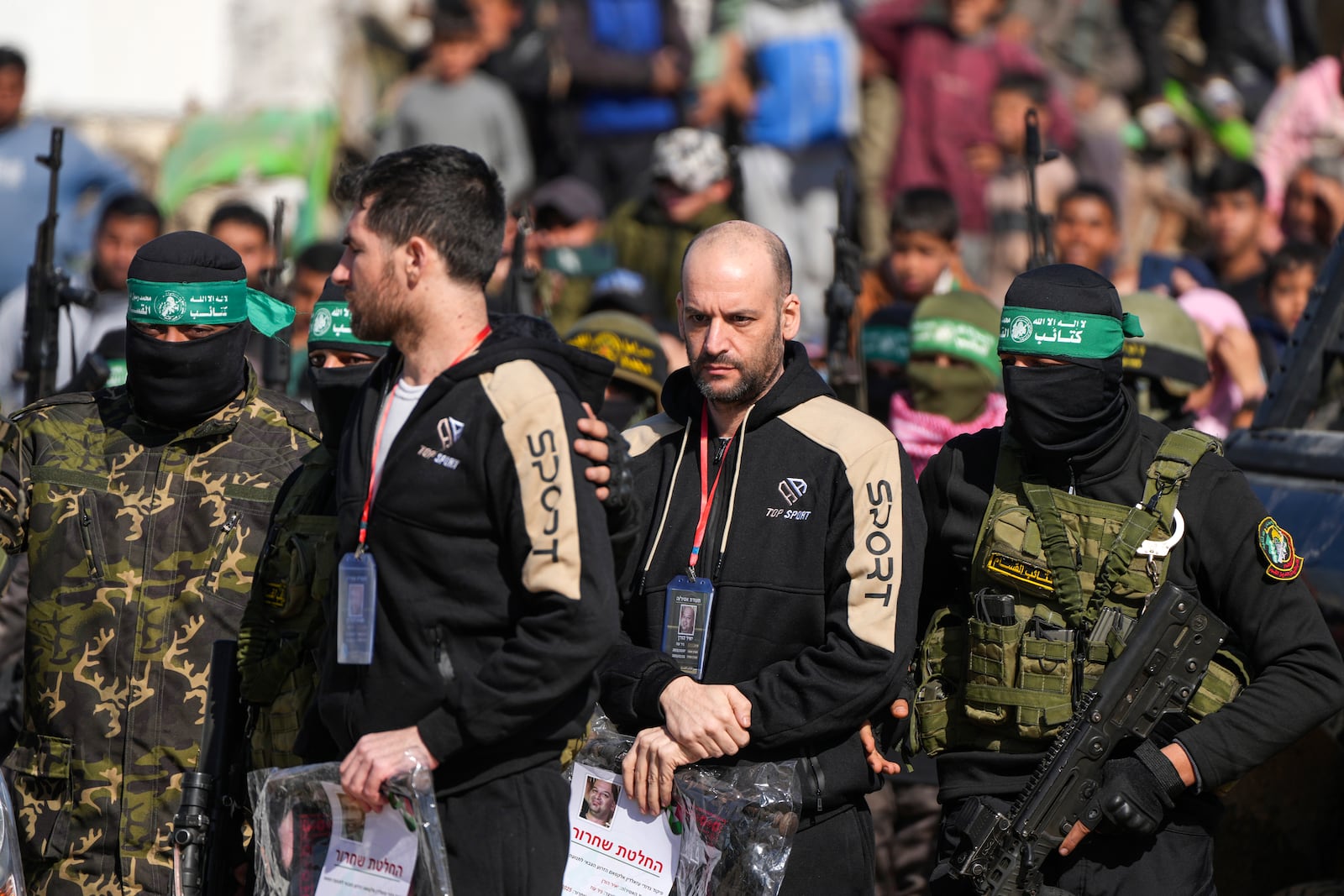 Hostages Sagui Dekel Chen, 36, left, Israeli-American and Iair Horn, 46, Israeli-Argentine, are escorted by Hamas fighters before being handed over to the Red Cross in Khan Younis, Gaza Strip, Saturday, Feb. 15, 2025. (AP Photo/Abdel Kareem Hana)