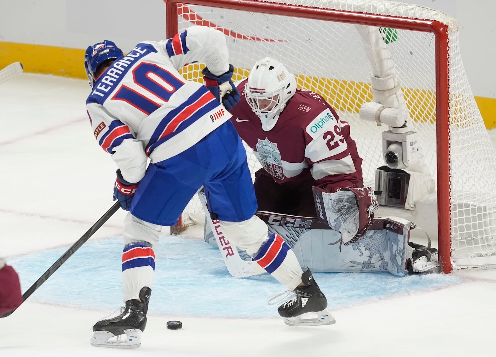 United States forward Carey Terrance (10) tries to put the puck past Latvia goaltender Linards Feldbergs (29) during the first period of a IIHF World Junior Hockey Championship tournament game, Saturday, Dec.28, 2024 in Ottawa, Ontario. (Adrian Wyld/The Canadian Press via AP)