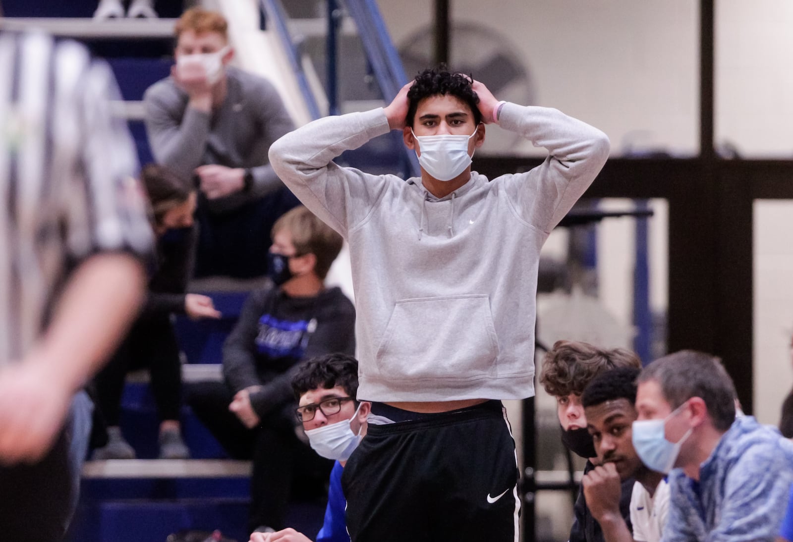 E.J. Kapihe stands up from the bench during Hamilton's basketball game against Lakota West Friday, January 22, 2021 at Hamilton High School. Kapihe, who came to Hamilton this season after basketball in Hawaii got canceled, did not dress for the game. NICK GRAHAM / STAFF 