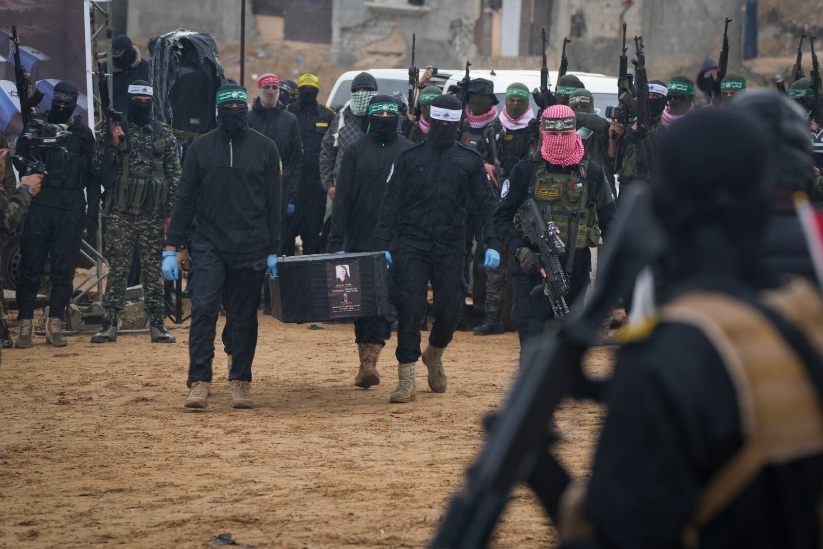 Palestinian militant fighters carry the coffin containing the body of Shiri Bibas one of four Israeli hostages, including her children Ariel and Kfir and Oded Lifshitz, who was 83, as their are handed over to the Red Cross in Khan Younis, southern Gaza Strip, Thursday, Feb. 20, 2025. (AP Photo/Abdel Kareem Hana)