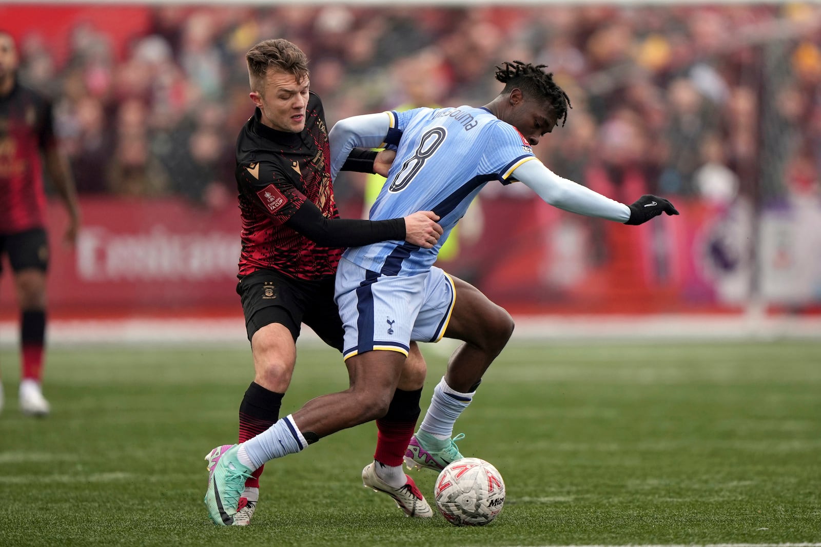 Tottenham Hotspur's Yves Bissouma, right, and Tamworth's Ben Milnes battle for the ball during the English FA Cup third round match at The Lamb Ground, Tamworth, England, Sunday Jan. 12, 2025. (Joe Giddens/PA via AP)