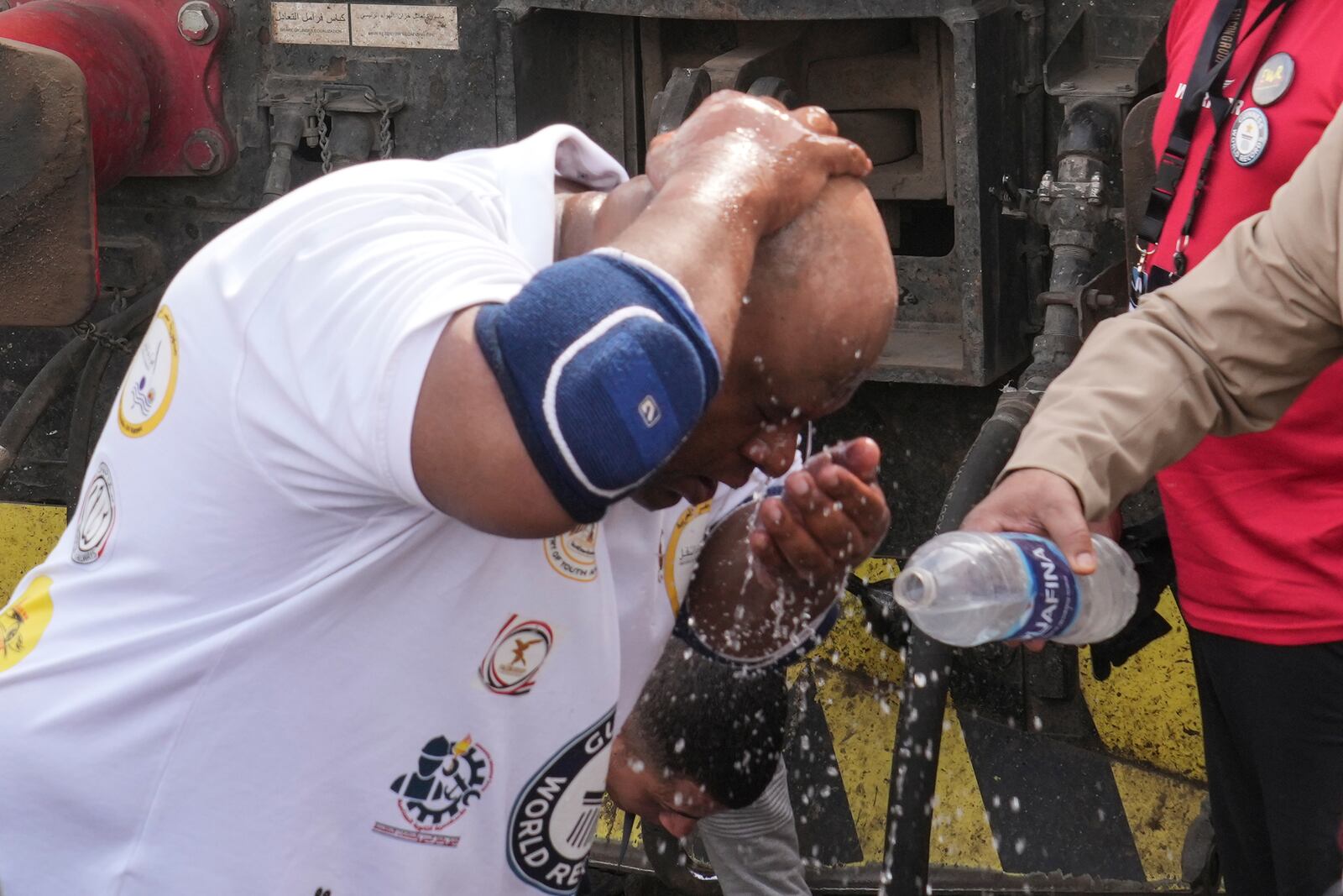 Egyptian wrestler Ashraf Mahrous, better known as Kabonga, washes his face before pulling a train for nearly 10 meters (33 feet) at Ramses Station in Cairo, Egypt, Thursday, March 13, 2025. (AP Photo/Amr Nabil)