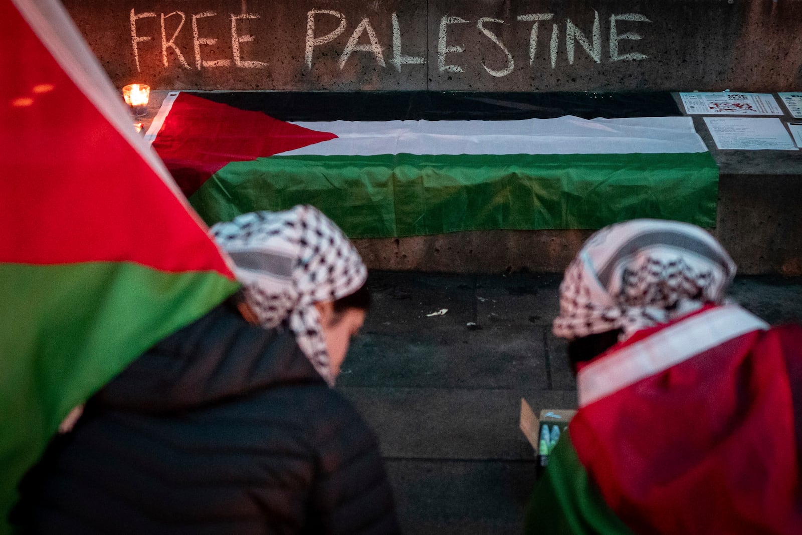 People write in chalk during a gathering to celebrate the Gaza ceasefire and hostage deal reached between Israel and Hamas in Vancouver, British Columbia, Wednesday, Jan. 15, 2025. (Ethan Cairns/The Canadian Press via AP)