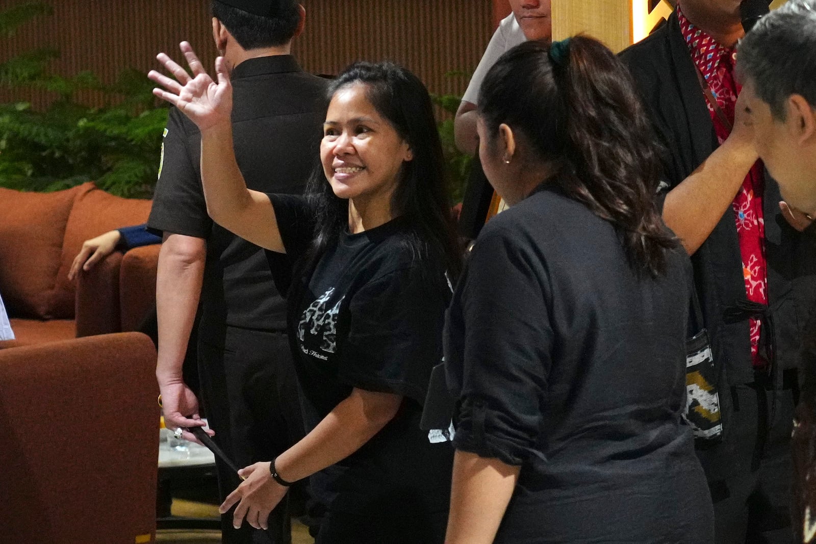 Mary Jane Veloso, center, a Filipina who was on death row in Indonesia and was nearly executed by firing squad in 2015, waves good bye after a press conference ahead of her repatriation to the Philippines, at Soekarno-Hatta International Airport in Tangerang, Indonesia, Tuesday, Dec. 17, 2024. (AP Photo/Tatan Syuflana)