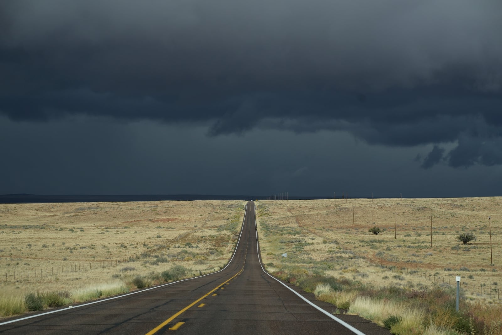 Storm clouds form on Highway 264, on the Navajo Nation, on the outskirts of Tuba City, Ariz., Friday, Oct. 18, 2024. Soaring unemployment and poverty has pushed young Navajos to leave their sacred lands in search of jobs. (AP Photo/Rodrigo Abd)