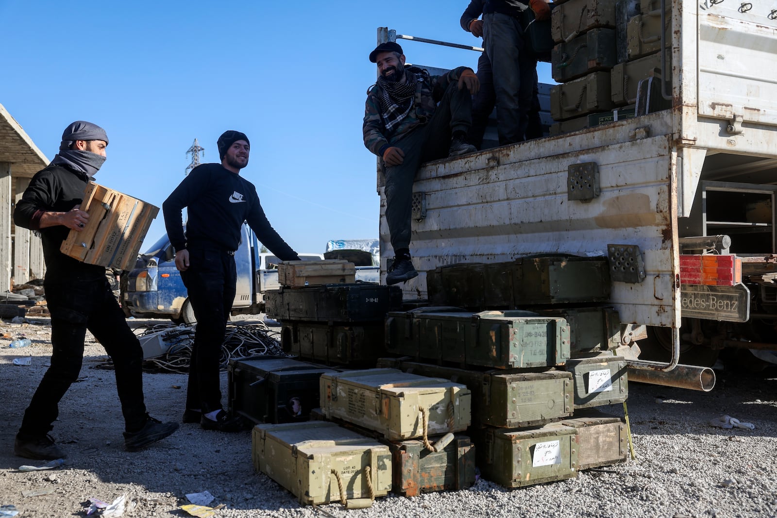 Syrian opposition fighters seize abandoned Syrian army ammunition in in the town of Khan Assubul, Syria, southwest of Aleppo, Sunday, Dec. 1, 2024. Syrian opposition insurgency launched a campaign on Wednesday with a two-pronged attack on Aleppo and the countryside around Idlib.(AP Photo/Ghaith Alsayed)