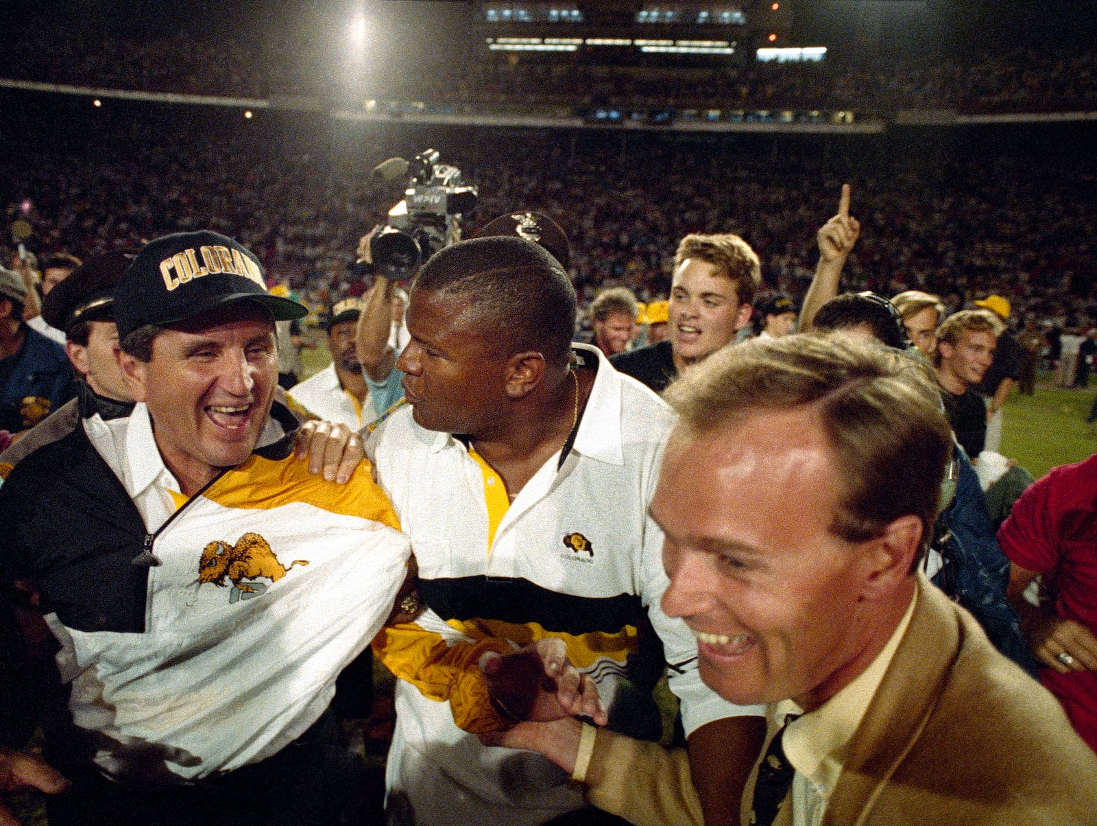 FILE - Colorado coach Bill McCartney, left, is escorted off the Orange Bowl field after the Buffaloes defeated Notre Dame, 10-9, in the 57th annual Orange Bowl Classic in Miami, Jan. 1, 1991. (AP Photo/Ray Fairall, File)