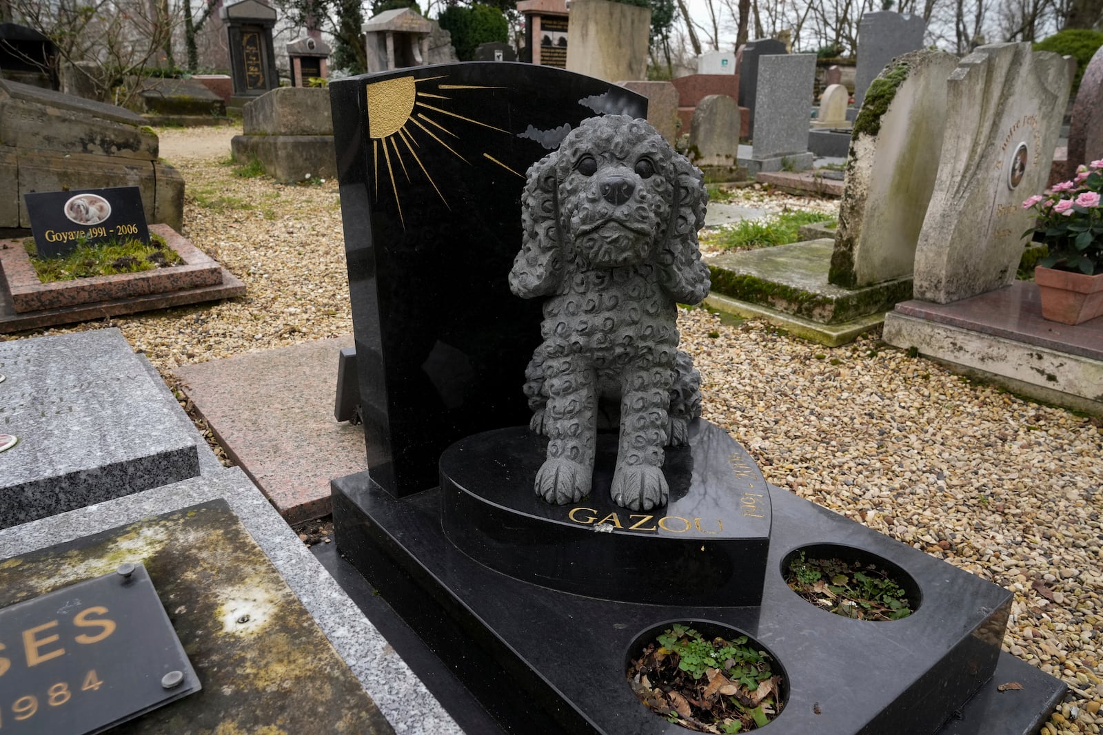 A grave for a dog named "Gazou" is seen at the pet cemetery of Asnieres-sur-Seine, west of Paris, Friday, Feb. 21, 2025. (AP Photo/Michel Euler)