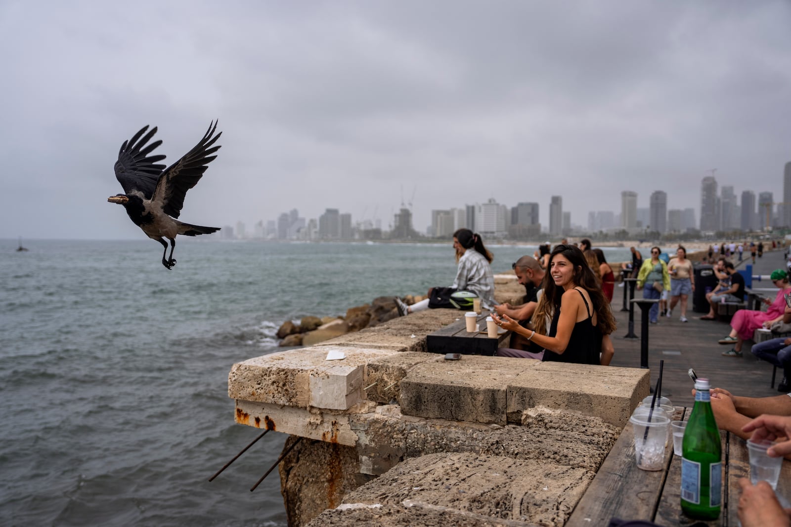 FILE - People sit in a bar overlooking the Mediterranean Sea at the old port of Jaffa, a mixed Jewish-Arab part of Tel Aviv, Israel, on April 26, 2024. (AP Photo/Oded Balilty, File)