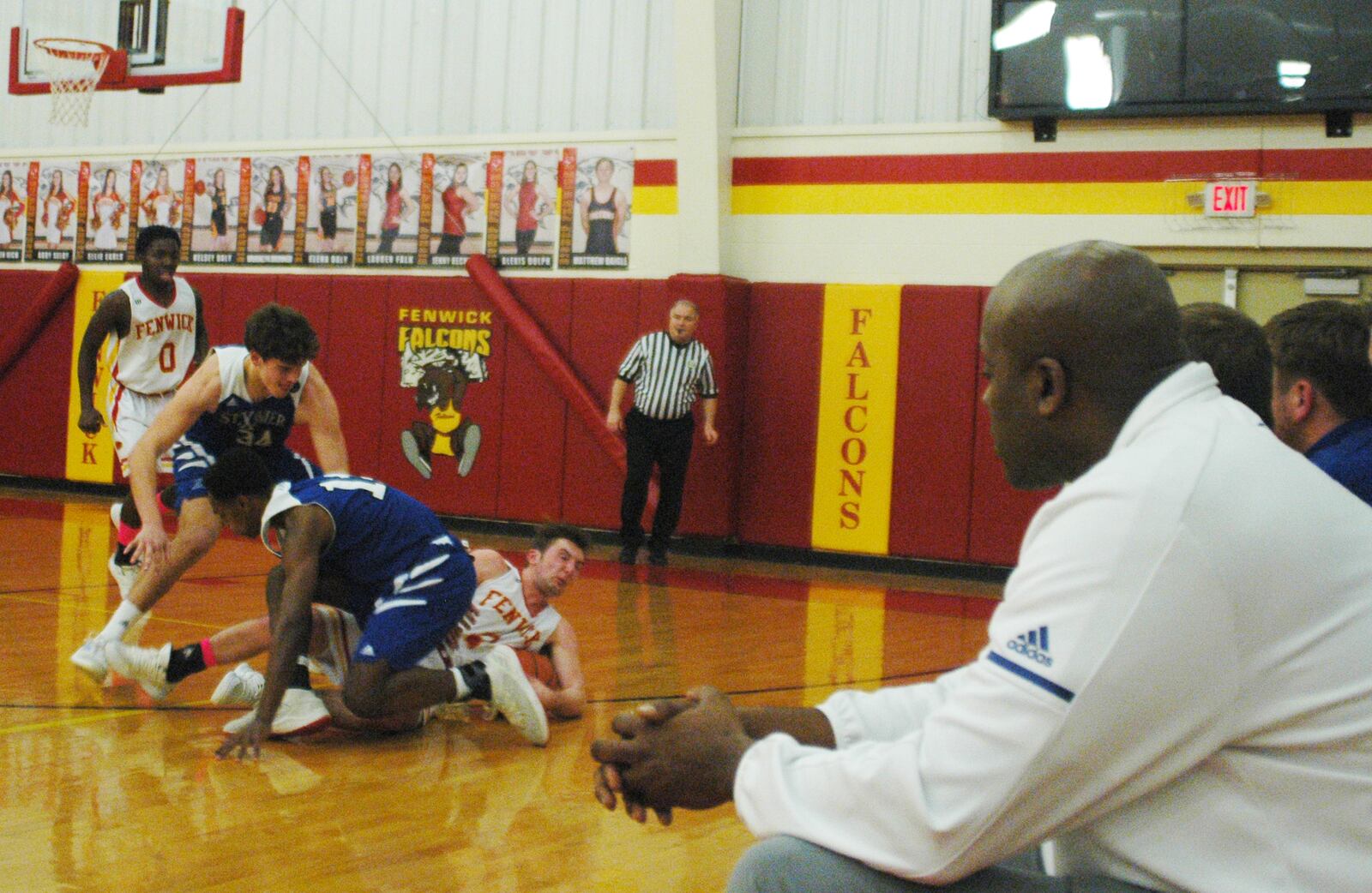 The St. Xavier bench watches as the Bombers' Thomas Kiessling (34) and B.J. Bransford (14) battle Fenwick's Jared Morris for the ball during Saturday night's game at Fenwick. The host Falcons won 58-53. RICK CASSANO/STAFF