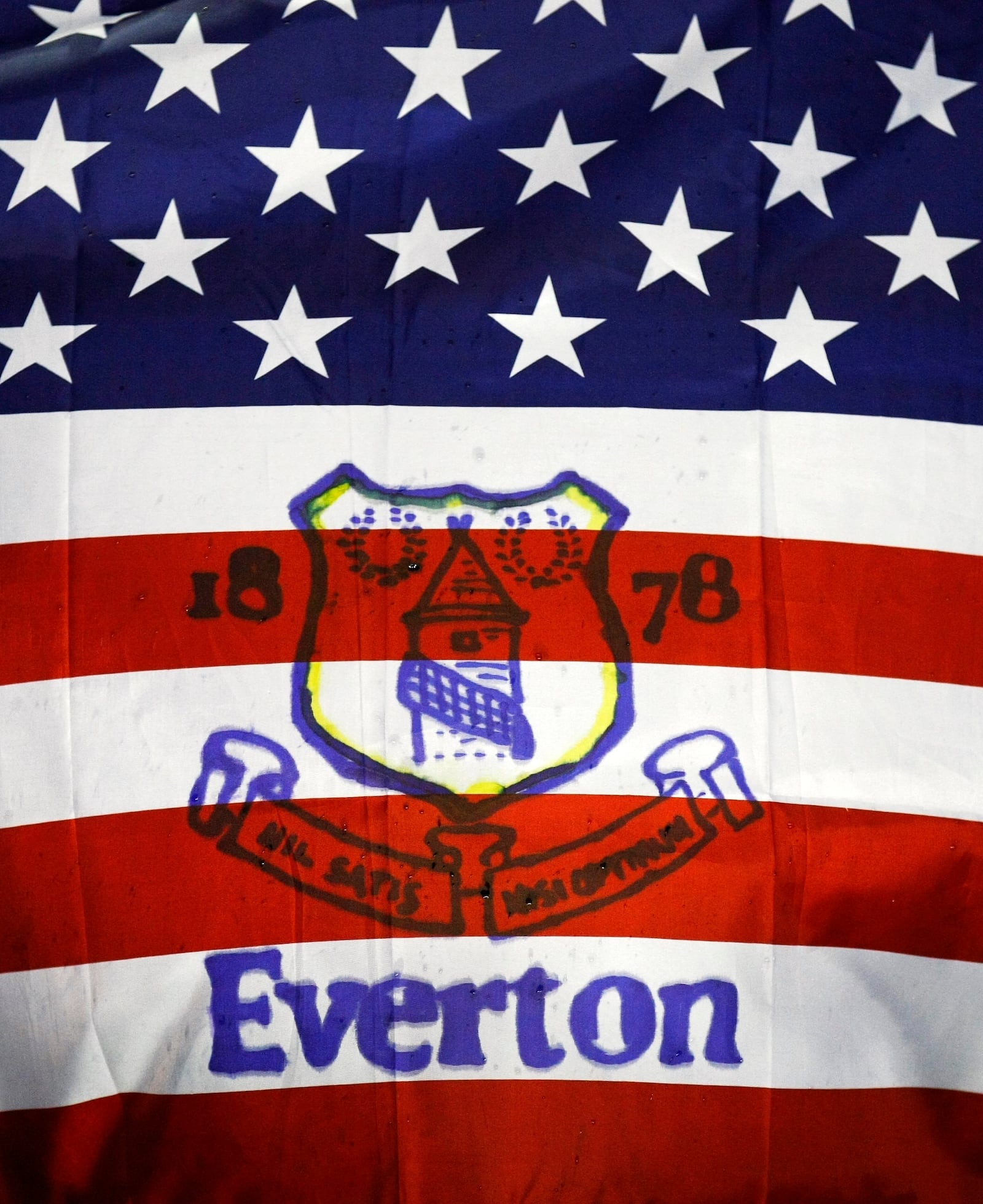 FILE - Fans hold a flag before the English Premier League soccer match between Everton and Bolton at Goodison Park, Liverpool, England, Wednesday Jan. 4, 2012. (AP Photo/Tim Hales, File)