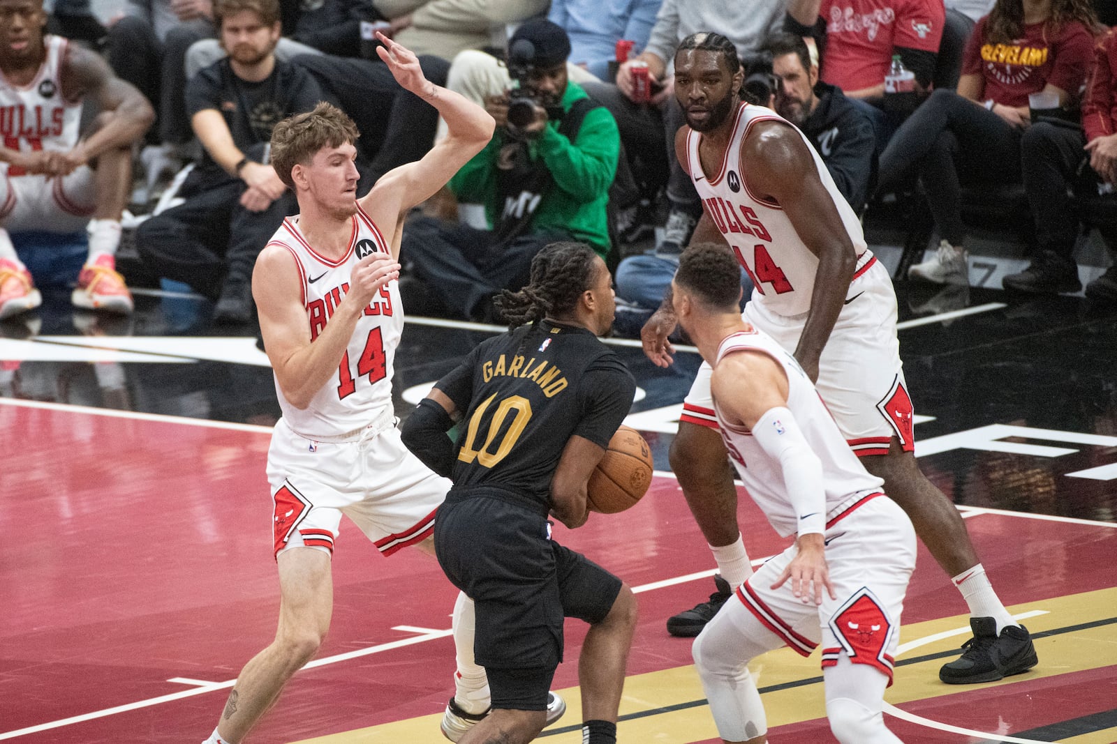 Cleveland Cavaliers' Darius Garland (10) drives between Chicago Bulls' Matas Buzelis (14), Dalen Terry, front right, and Patrick Williams, back right, during the first half of an Emirates NBA cup basketball game in Cleveland, Friday, Nov 15, 2024. (AP Photo/Phil Long)