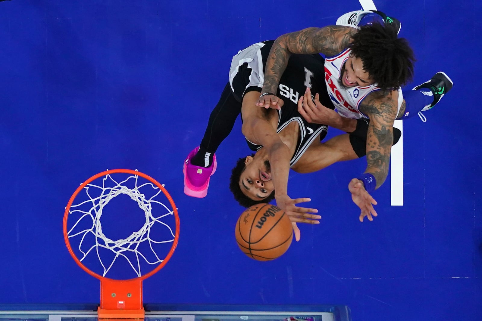 Philadelphia 76ers' Kelly Oubre Jr., right, goes up for a shot against San Antonio Spurs' Victor Wembanyama during the second half of an NBA basketball game, Monday, Dec. 23, 2024, in Philadelphia. (AP Photo/Matt Slocum)