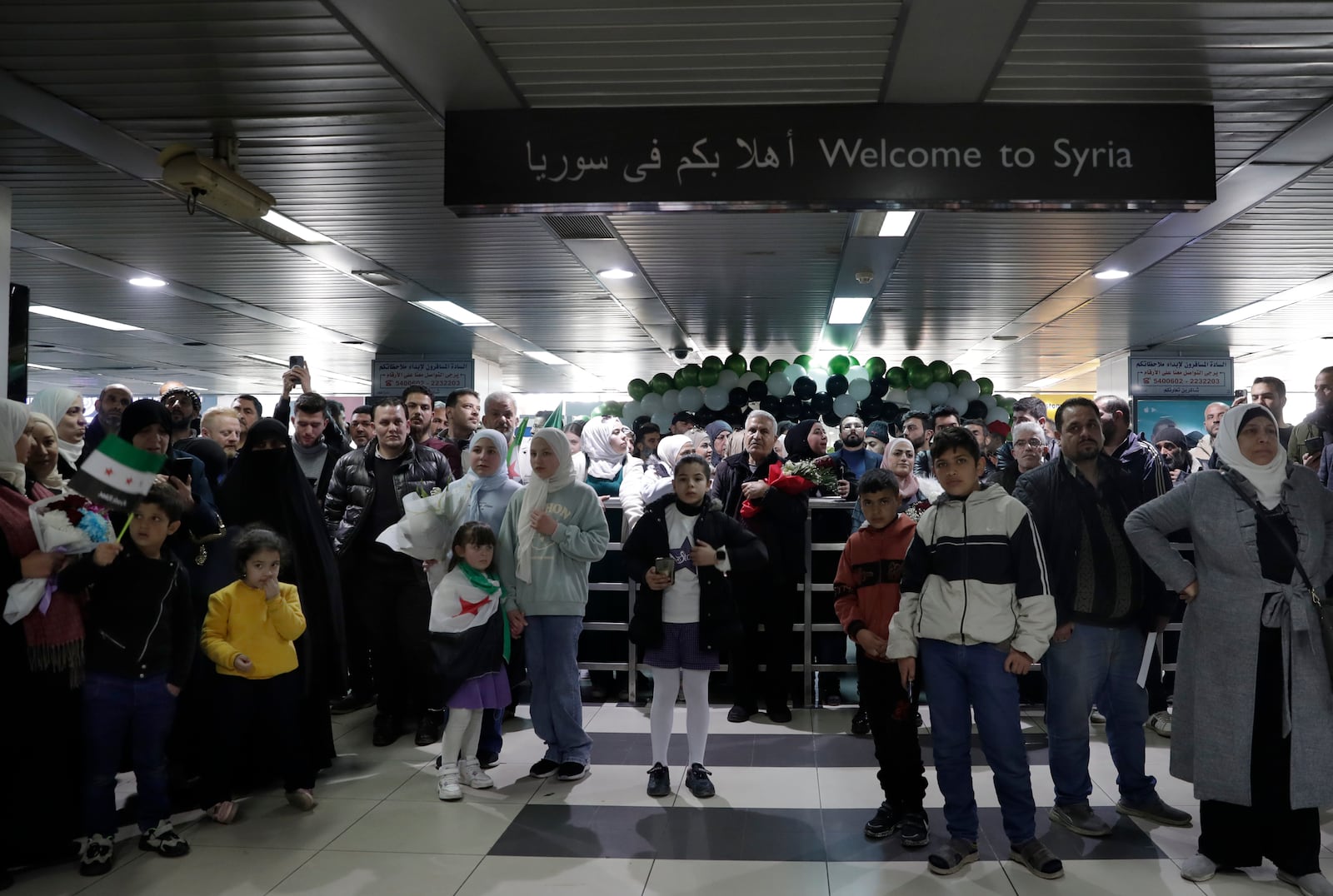 People wait to receive their relatives at the arrival terminal, after a first international commercial flight since the fall of former Syrian President Bashar Assad landed at Damascus international airport, in Damascus, Syria, Tuesday, Jan. 7, 2025. (AP Photo/Omar Sanadiki)