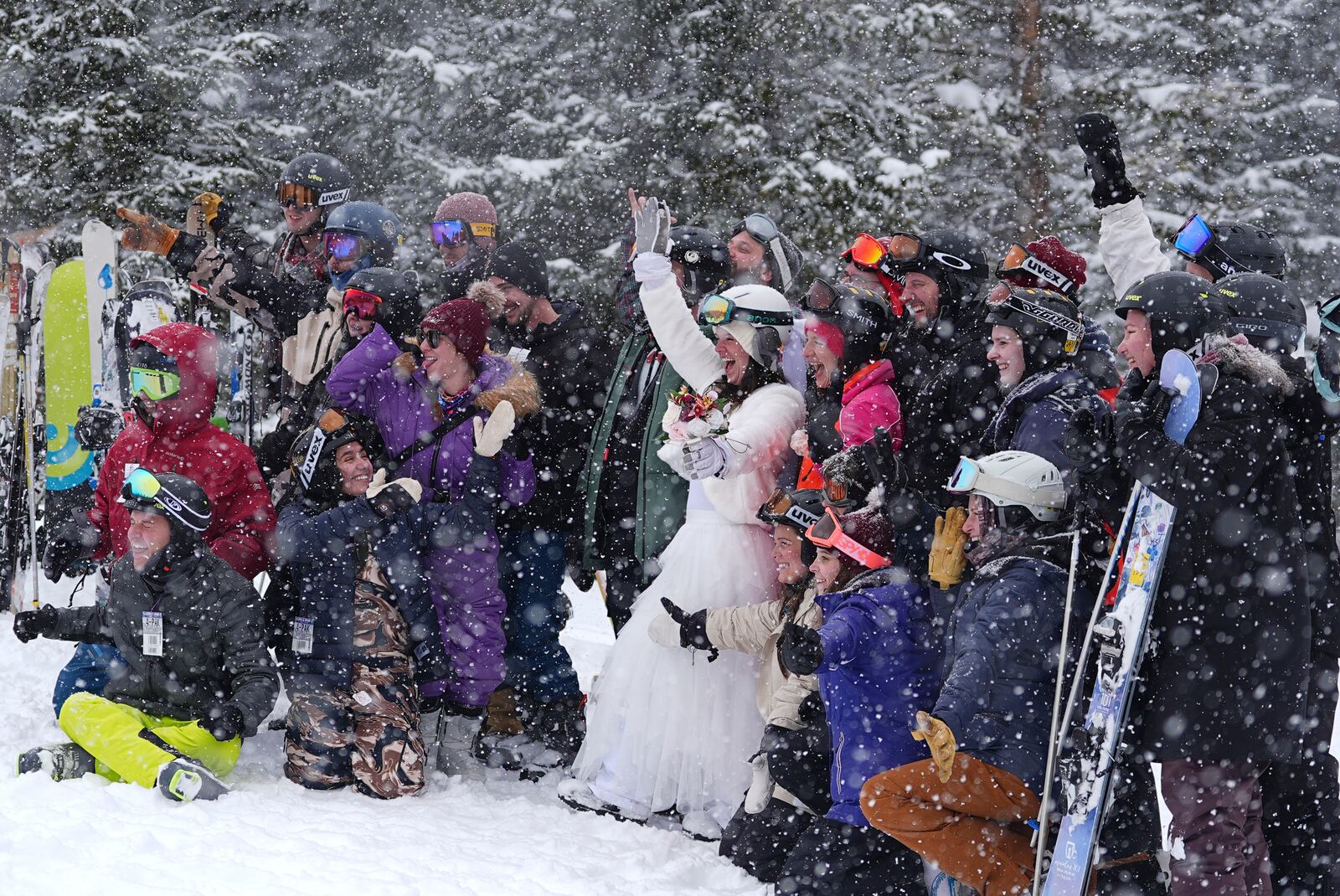 Bride Julia Wicks, center, of Minneapolis, waves as her wedding party pose for a group photo at the 35th annual Marry Me & Ski for Free Valentine's Day mountaintop matrimony ceremony, Friday, Feb. 14, 2025, at Loveland Ski Area, Colo. (AP Photo/David Zalubowski)