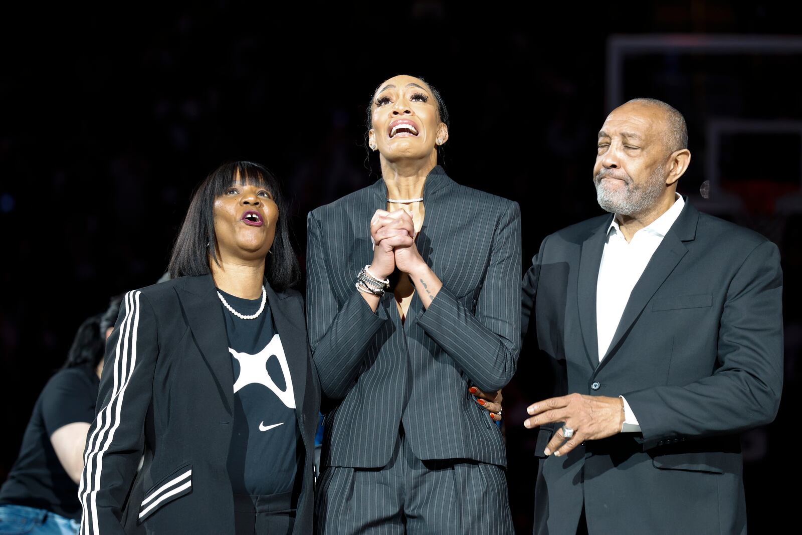 A'ja Wilson, center, stands with her parents Eva and Roscoe Wilson as they watch her number be retired during a ceremony before an NCAA college basketball game between South Carolina and Auburn in Columbia, S.C., Sunday, Feb. 2, 2025. (AP Photo/Nell Redmond)