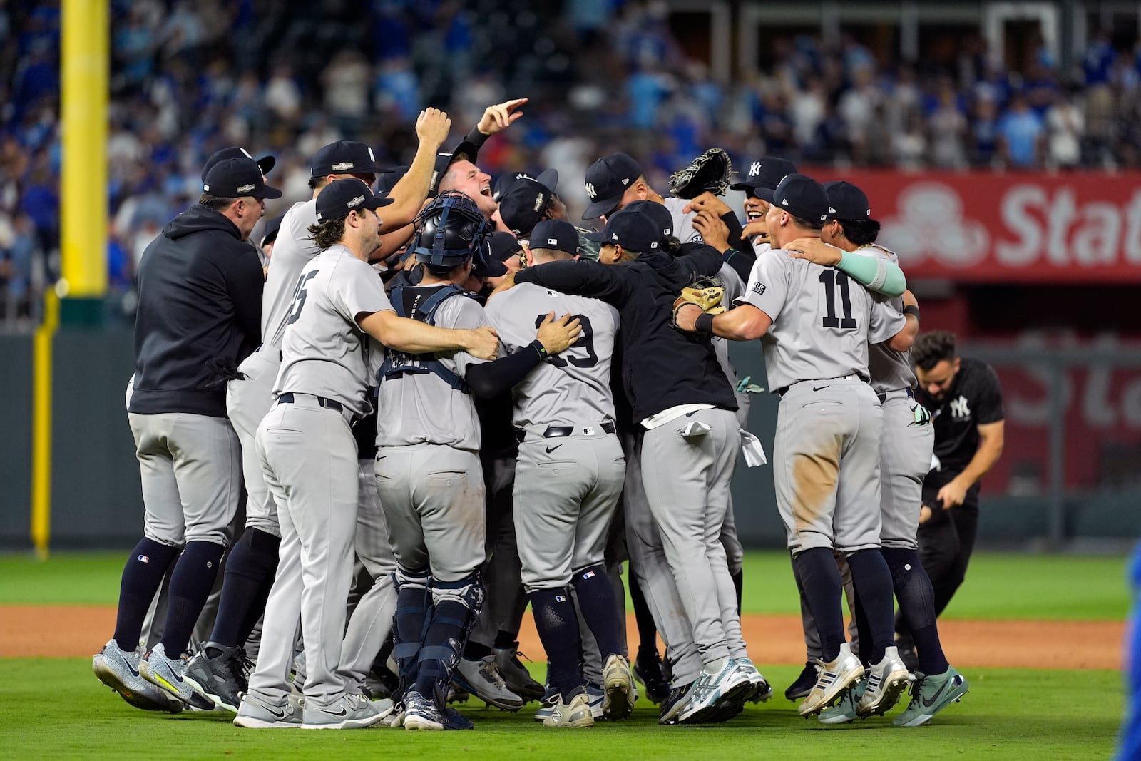 Members of the New York Yankees celebrate after defeating the Kansas City Royals 3-1 in Game 4 of an American League Division baseball playoff series and move on to the ALCS Thursday, Oct. 10, 2024, in Kansas City, Mo. (AP Photo/Charlie Riedel)