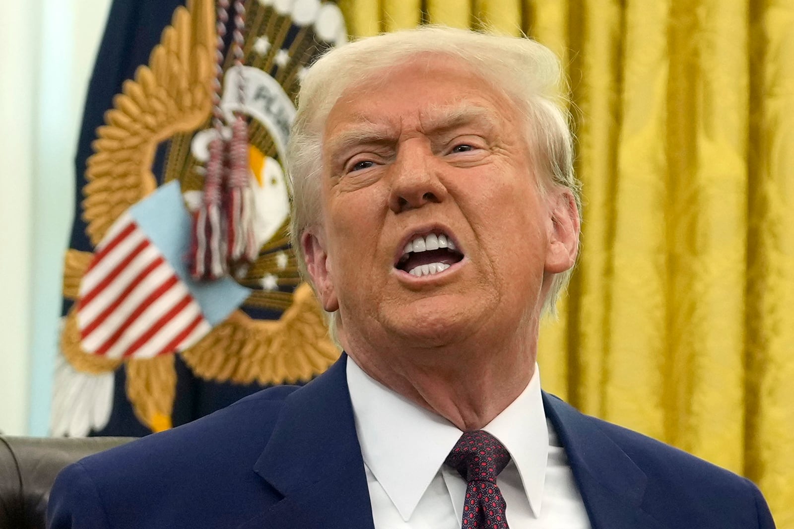 President Donald Trump speaks to reporters after signing an executive order in the Oval Office of the White House, Thursday, Feb. 13, 2025, in Washington. (AP Photo/Ben Curtis)