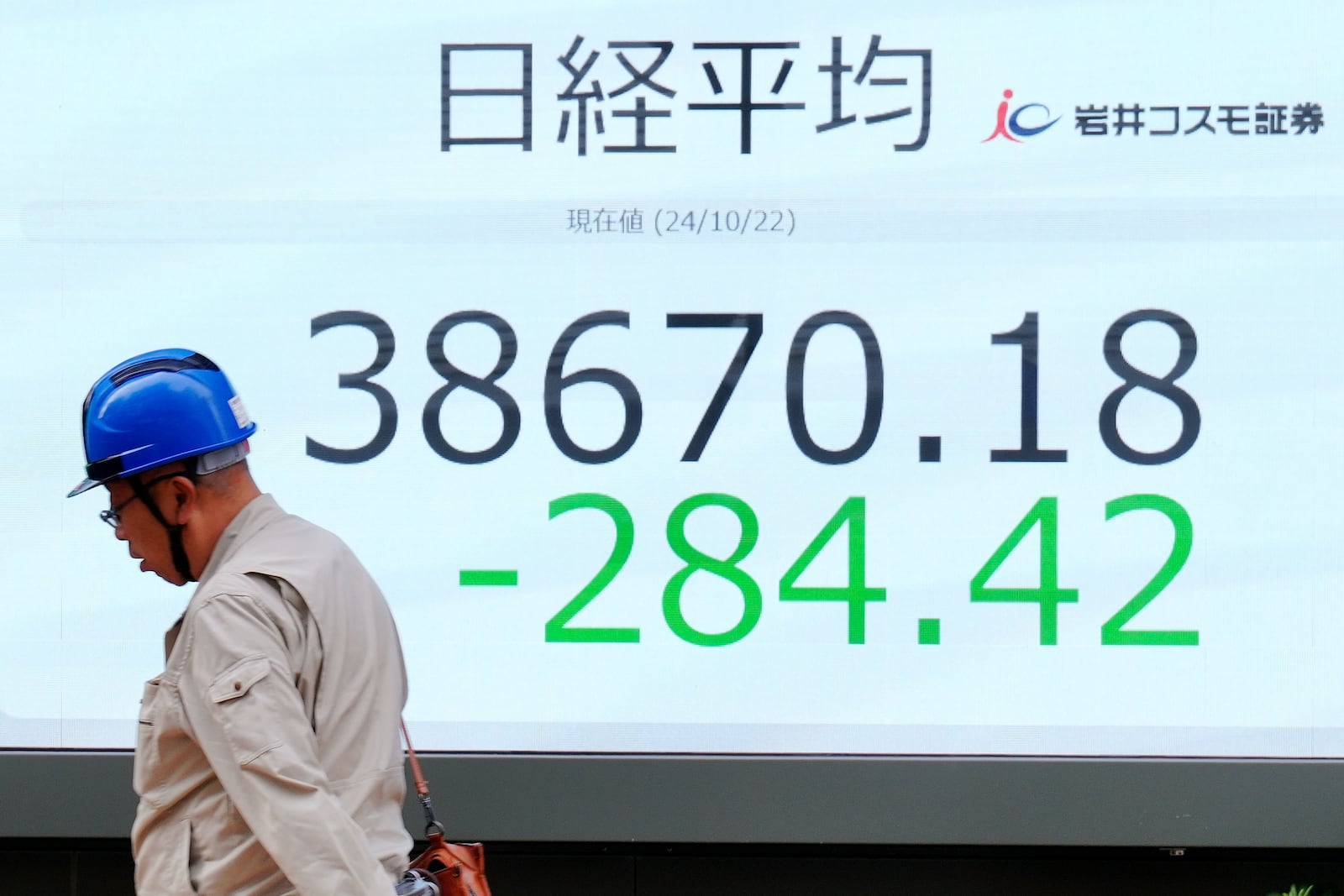 A person walks in front of an electronic stock board showing Japan's Nikkei index at a securities firm Tuesday, Oct. 22, 2024, in Tokyo. (AP Photo/Eugene Hoshiko)