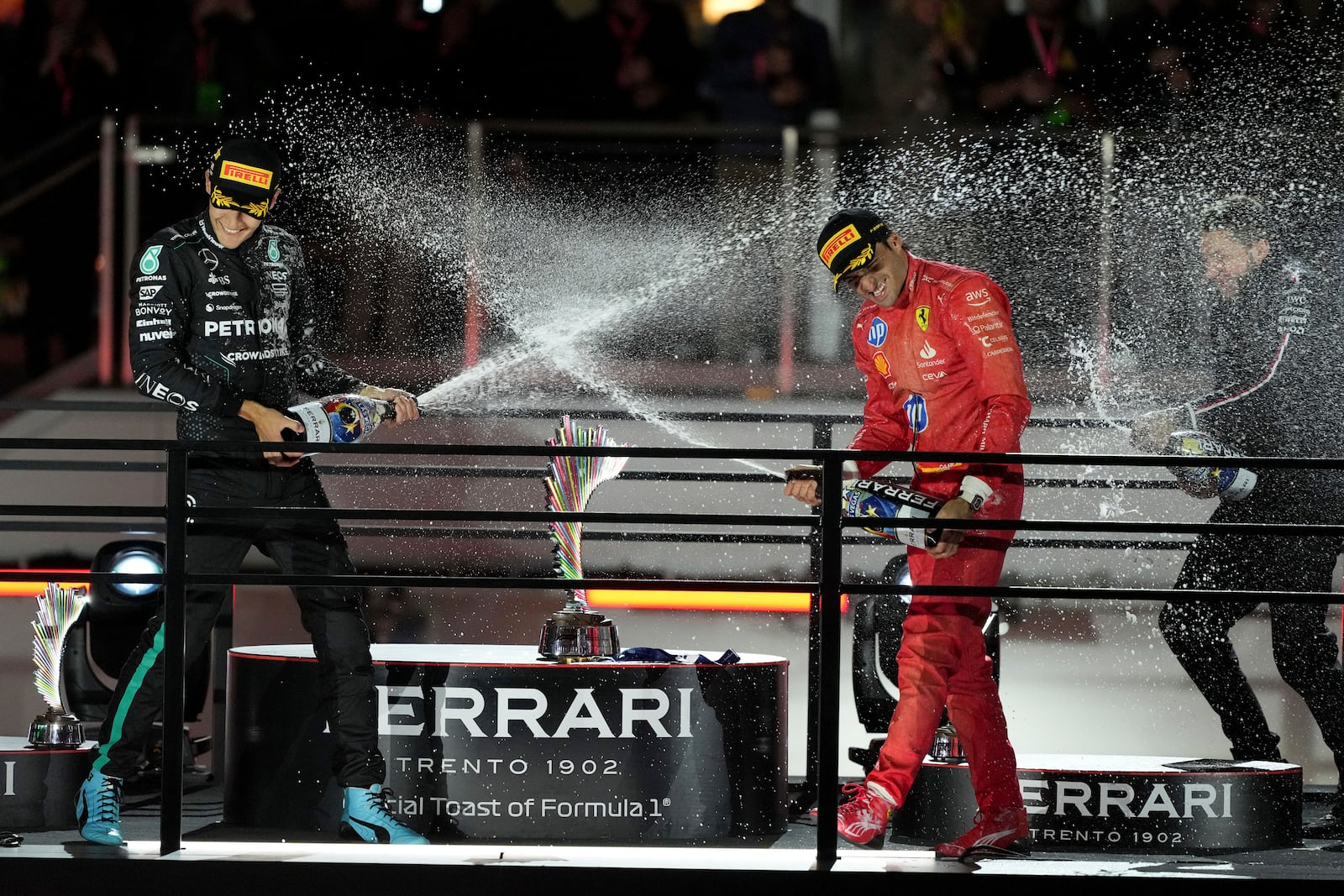 Mercedes driver George Russell, of Britain, left, sprays champagne on Ferrari driver Carlos Sainz, of Spain, after the F1 Las Vegas Grand Prix auto race, Saturday, Nov. 23, 2024, in Las Vegas.(AP Photo/Rick Scuteri)