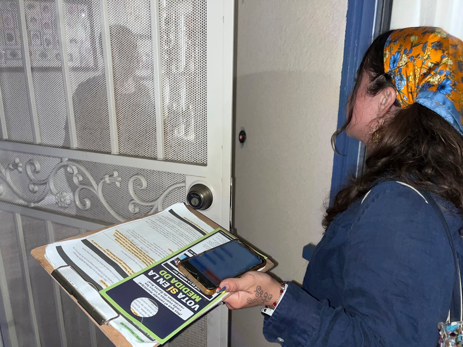 Tania Ortega, 27, speaks with a Santa Ana, Calif. resident on Wednesday, Oct. 23, 2024, about Measure DD, which would allow noncitizens to vote in local elections. (AP Photo/Jaimie Ding)