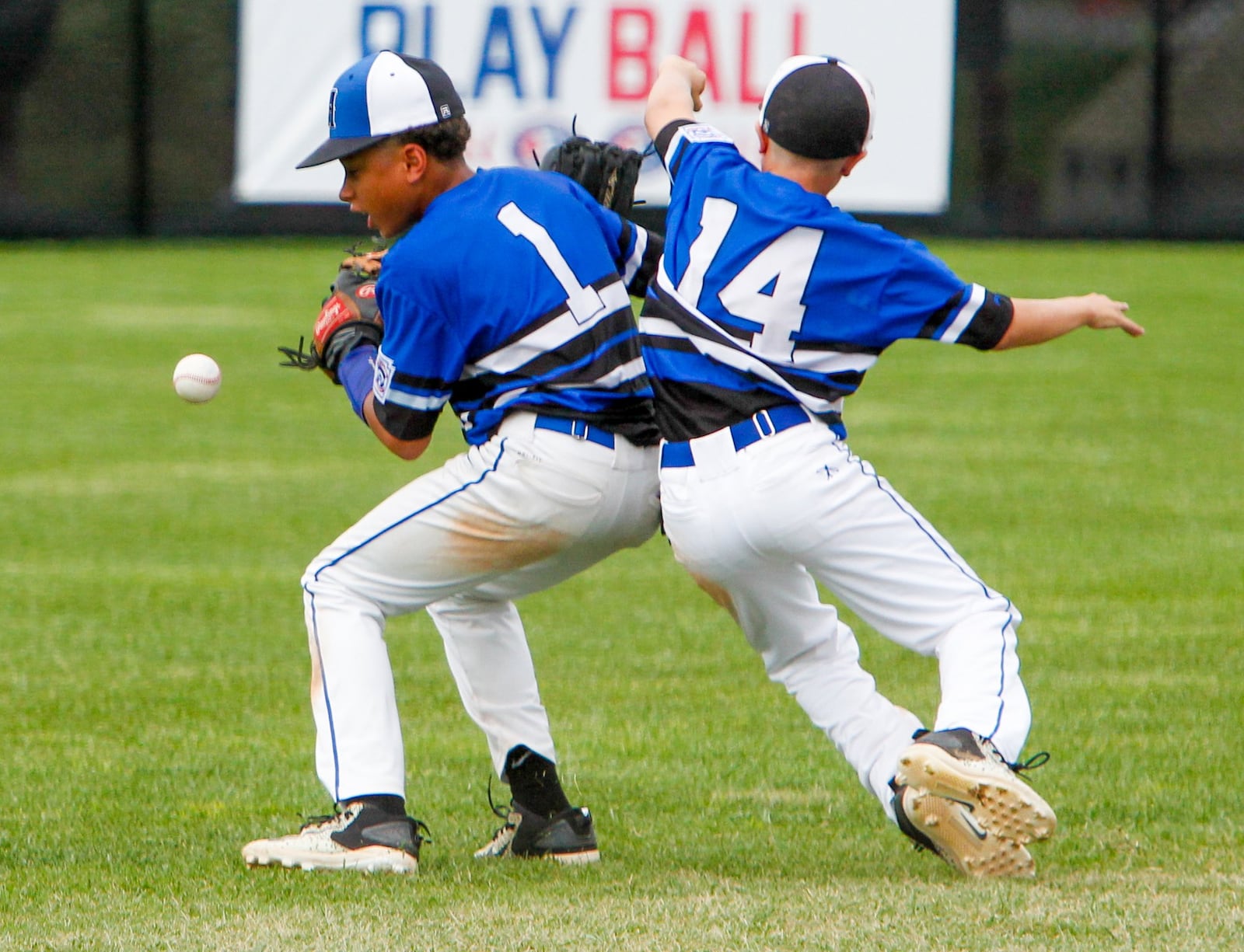 Hamilton West Side shortstop Braedyn Moore (1) and second baseman Nick Brosius (14) collide on a pop-up in short center field during their Little League Great Lakes Regional game against Wausau National (Wis.) at Grand Park Sports Campus in Westfield, Ind., on Sunday. West Side still got an out on the play, thanks to center fielder Clint Moak. GREG LYNCH/STAFF