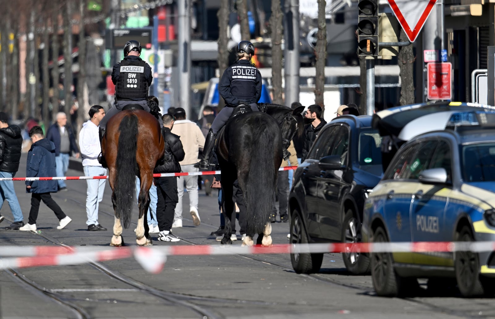 Mounted police officers work in the city center of Mannheim, Germany, Monday March 3, 2025, following an incident in which one person was killed and others injured when a car rammed into a crowd, German police said. (Boris Roessler/dpa via AP)