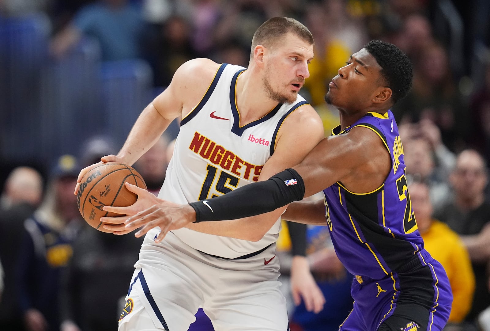 Denver Nuggets center Nikola Jokic, left, looks to pass the ball as Los Angeles Lakers forward Rui Hachimura defends in the first half of an NBA basketball game Saturday, Feb. 22, 2025, in Denver. (AP Photo/David Zalubowski)