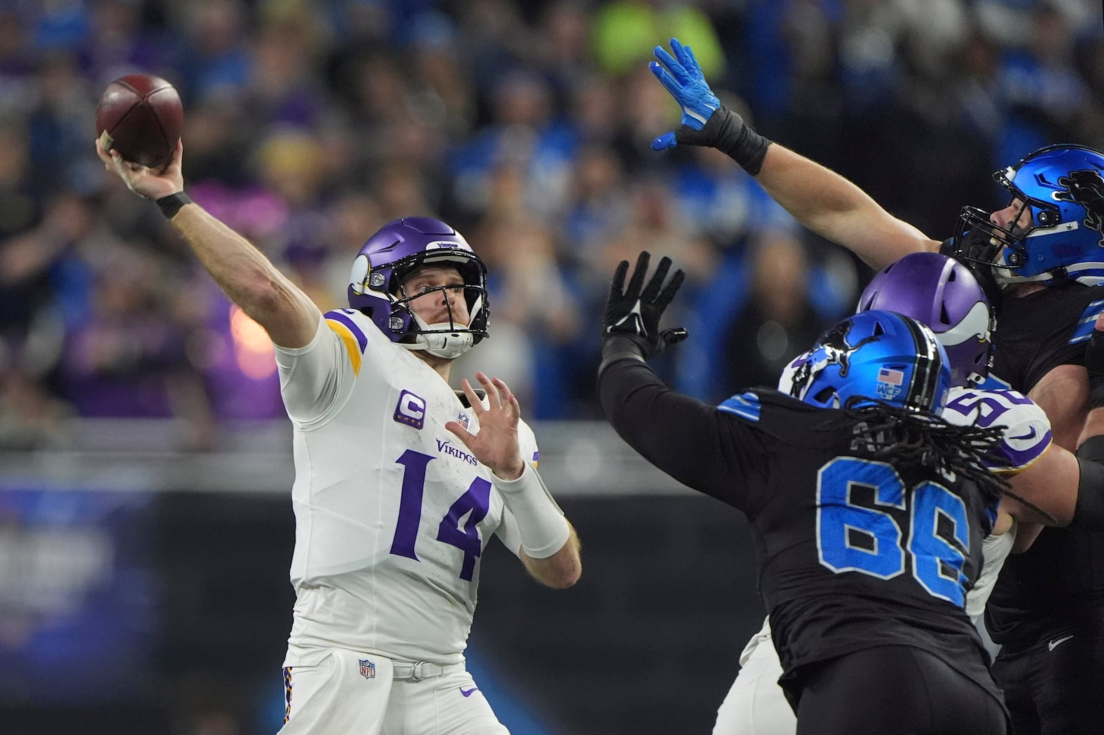 Minnesota Vikings quarterback Sam Darnold (14) throws against the Detroit Lions under pressure during the first half of an NFL football game Sunday, Jan. 5, 2025, in Detroit. (AP Photo/Charlie Riedel)