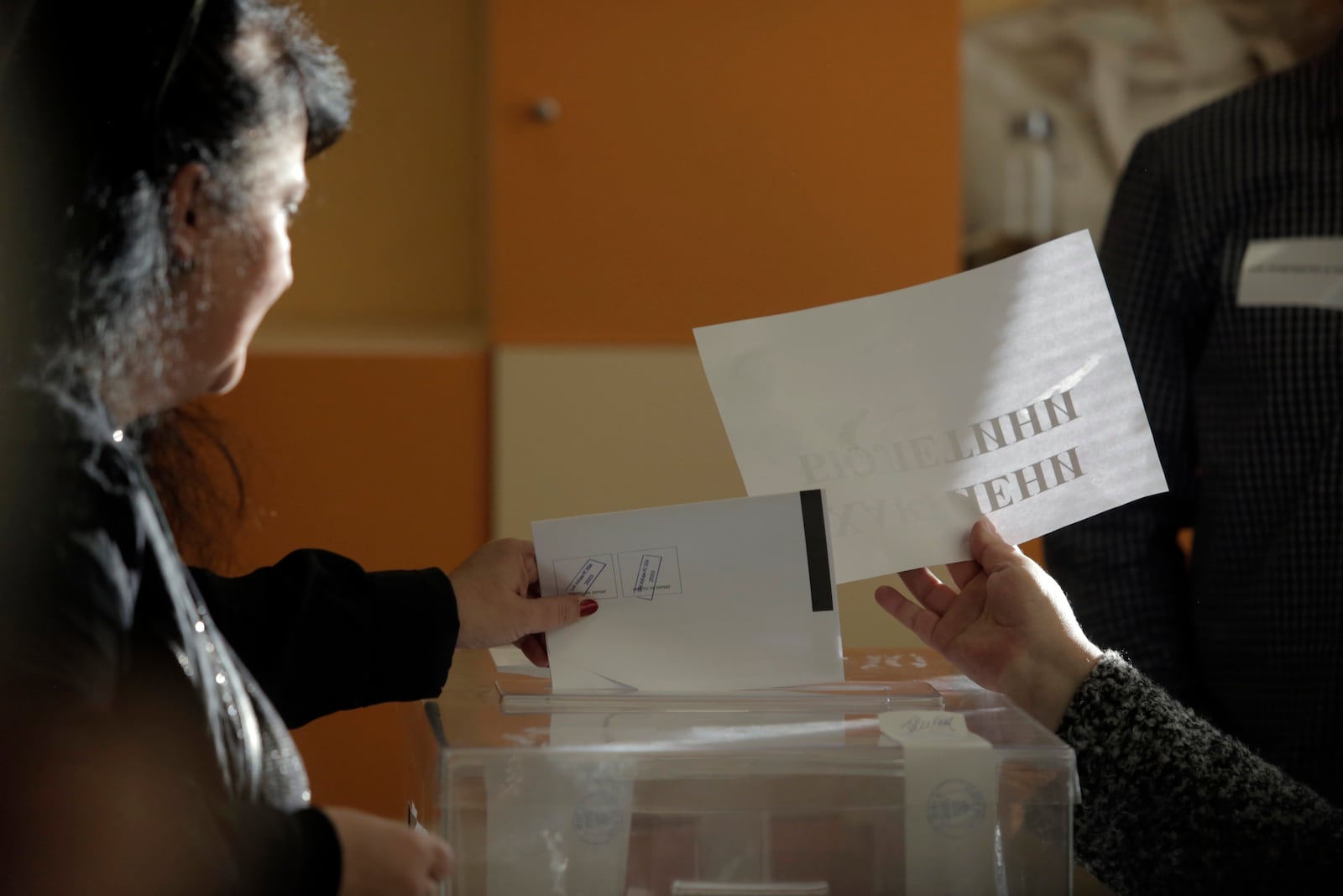 A woman casts a ballot at a polling station during the general elections in Sofia, Sunday, Oct. 27, 2024. (AP Photo/Valentina Petrova)