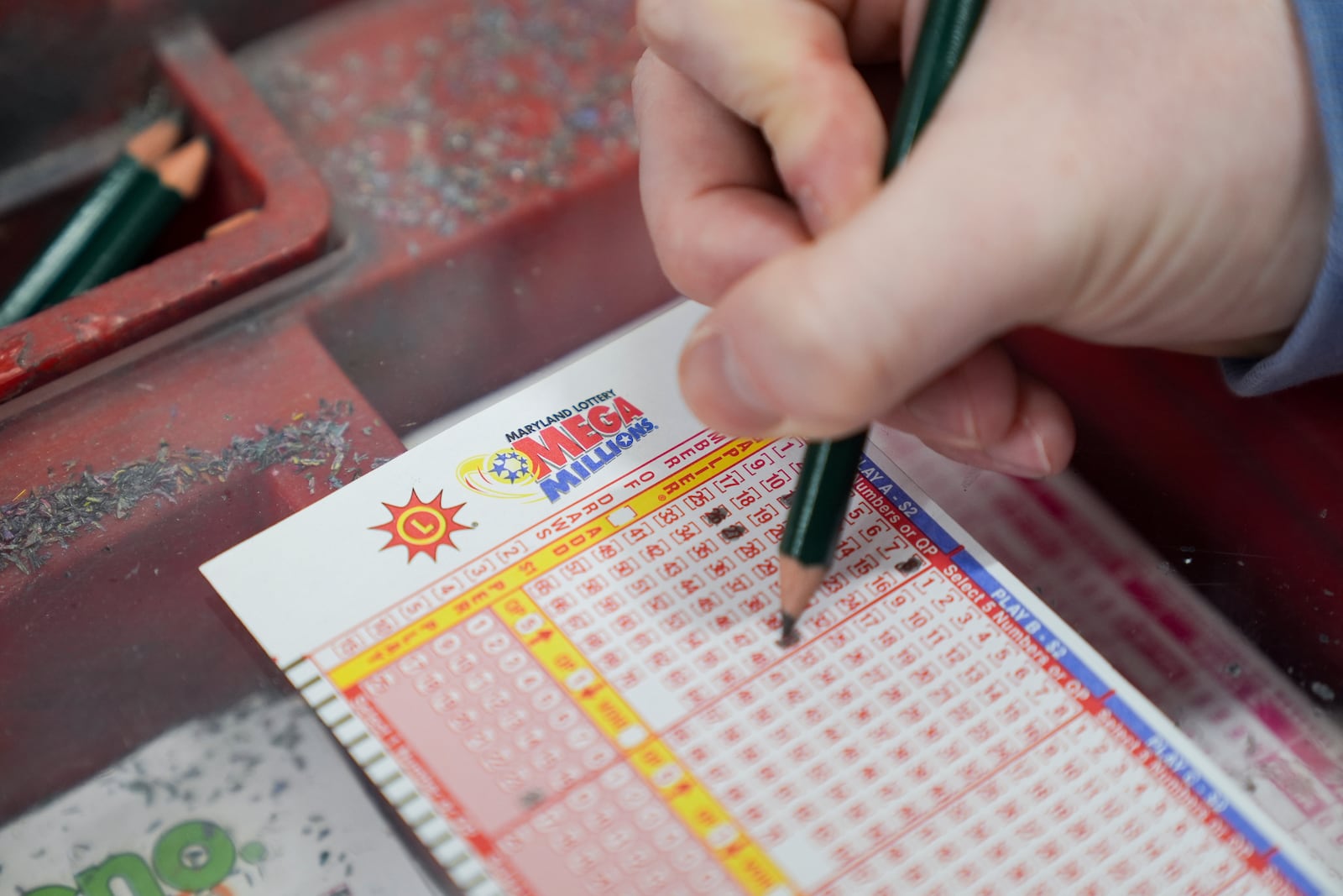 A person fills out a Mega Millions play slip ahead of Friday's Mega Millions drawing of $1.15 billion, Thursday, Dec. 26, 2024, in Baltimore. (AP Photo/Stephanie Scarbrough)