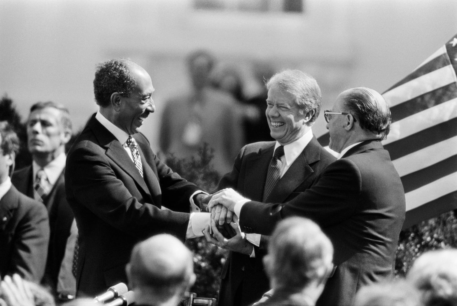 
                        FILE -- From left: President Anwar el-Sadat of Egypt, President Jimmy Carter and Prime Minister Menachem Begin of Israel in a three-way handshake after the signing of the peace treaty between Egypt and Israel at the White House in Washington, March 26, 1979. The living members of the exclusive club of Oval Office occupants said Carter would be remembered for his efforts to promote peace and democracy. (Neal Boenzi/The New York Times)
                      