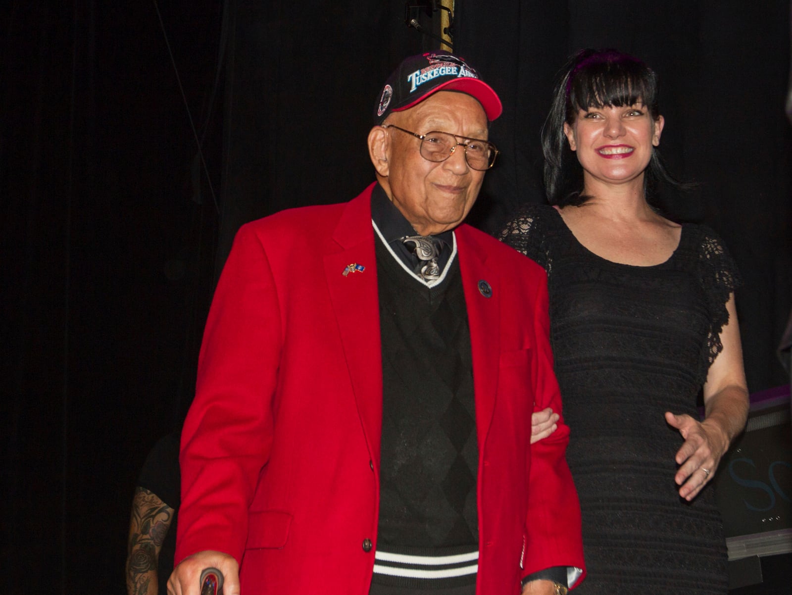 FILE - Actress Pauley Perrette, right, and Lt. Col. Bob Friend, a Tuskegee airman, stand onstage during the 2nd Annual Heroes Helping Heroes Benefit Concert at The House of Blues, Sept. 11, 2013, in Los Angeles. (Photo by Paul A. Hebert/Invision/AP, File)