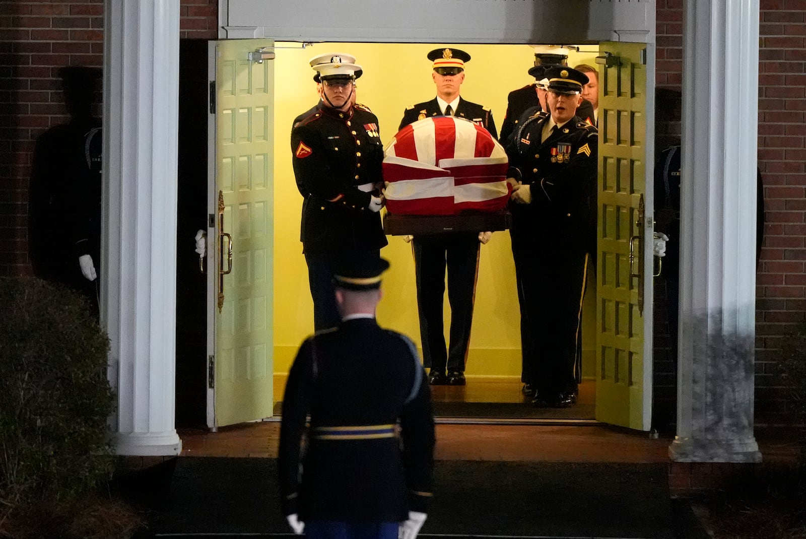 The flag-draped casket of former President Jimmy Carter is carried to a hearse after a funeral service at Maranatha Baptist Church, Thursday, Jan. 9, 2025, in Plains, Ga. (AP Photo/Mike Stewart)