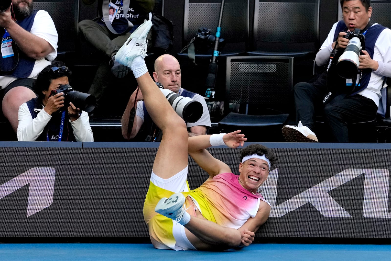 Ben Shelton of the U.S. falls into signboards after a fall during his quarterfinal match against Lorenzo Sonego of Italy at the Australian Open tennis championship in Melbourne, Australia, Wednesday, Jan. 22, 2025. (AP Photo/Ng Han Guan)