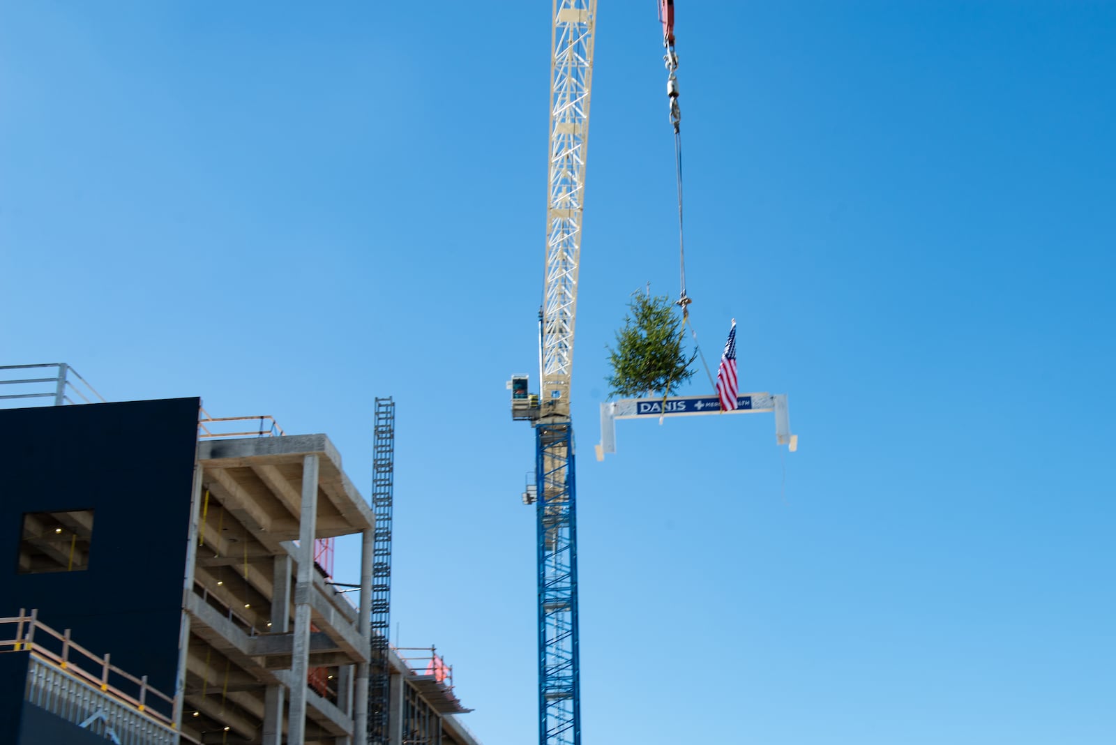 A Danis Construction crane hoists the beam with a U.S. flag and a small tree to celebrate the recent topping off ceremony at Mercy Health Kings Mills Hospital in Warren County. The new hospital is targeted for completion in late 2023. CONTRIBUTED/MERCY HEALTH