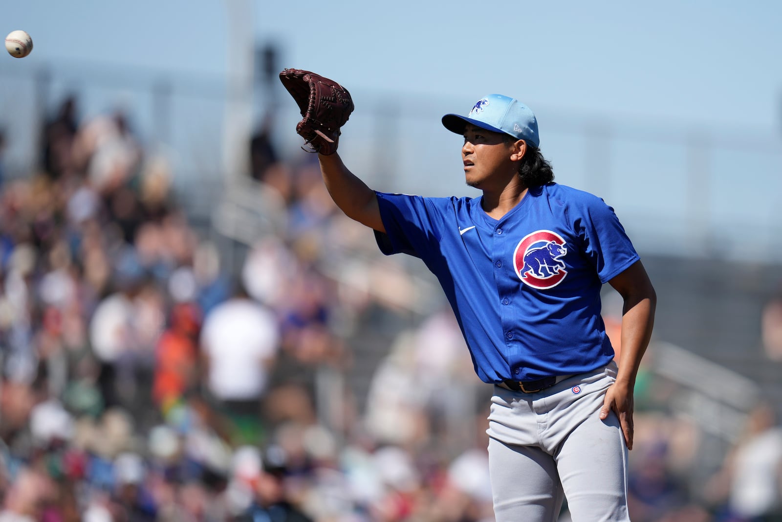 Chicago Cubs starting pitcher Shota Imanaga, of Japan, reaches out to catch a ball between pitches during the first inning of a spring training baseball game against the San Francisco Giants, Wednesday, Feb. 26, 2025, in Scottsdale, Ariz. (AP Photo/Ross D. Franklin)