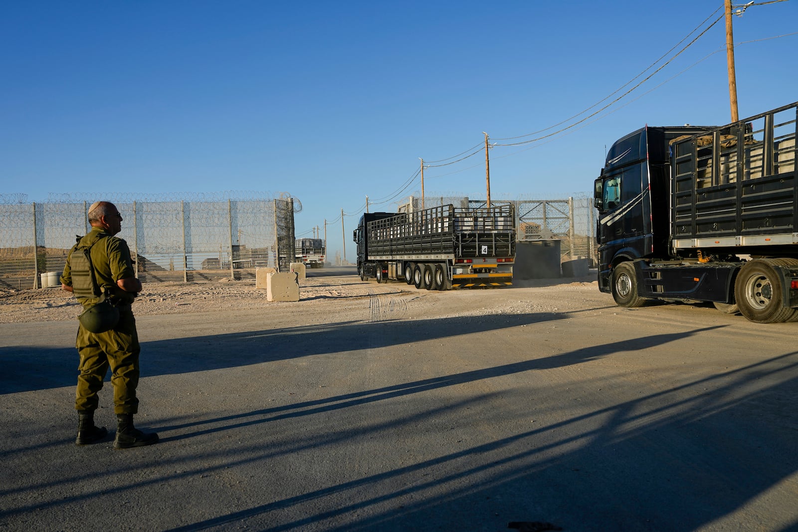 FILE - Trucks carrying humanitarian aid cross into the Gaza Strip from Erez crossing in southern Israel, on Oct. 21, 2024. (AP Photo/Tsafrir Abayov, File)