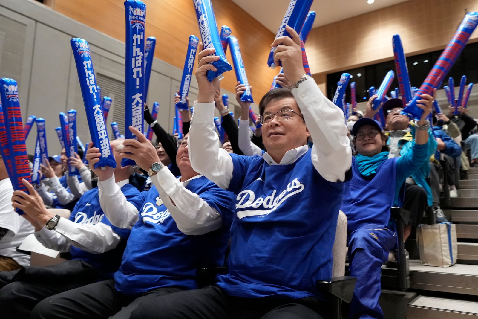 Oshu Mayor Jun Kuranari, center, and other people watch a live stream before the start of Game 3 of the baseball World Series between the Los Angeles Dodgers and the New York Yankees during a public viewing event in Oshu, northeastern Japan, the hometown of Shohei Ohtani of the Los Angeles Dodgers, Tuesday, Oct. 29, 2024. (AP Photo/Eugene Hoshiko)