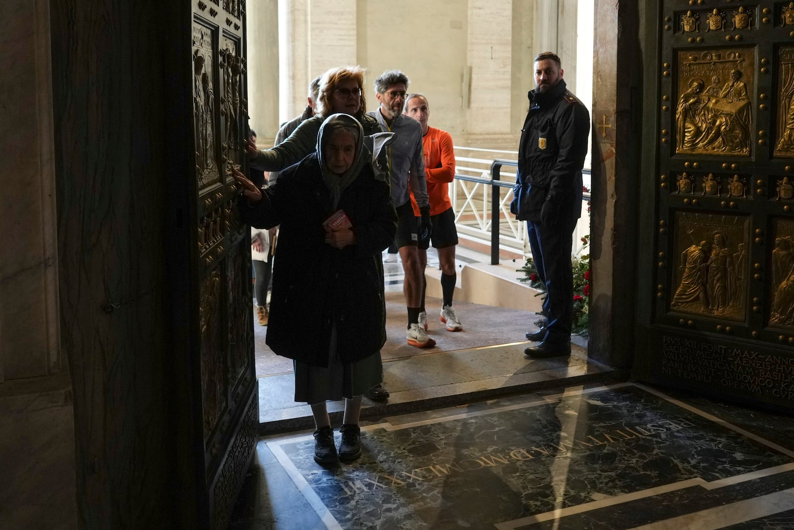 Faithful walk through the Holy Door of St.Peter's Basilica at the Vatican, Wednesday, Dec. 25, 2024, after it was opened by Pope Francis on Christmas Eve marking the start of the Catholic 2025 Jubilee. (AP Photo/Andrew Medichini)